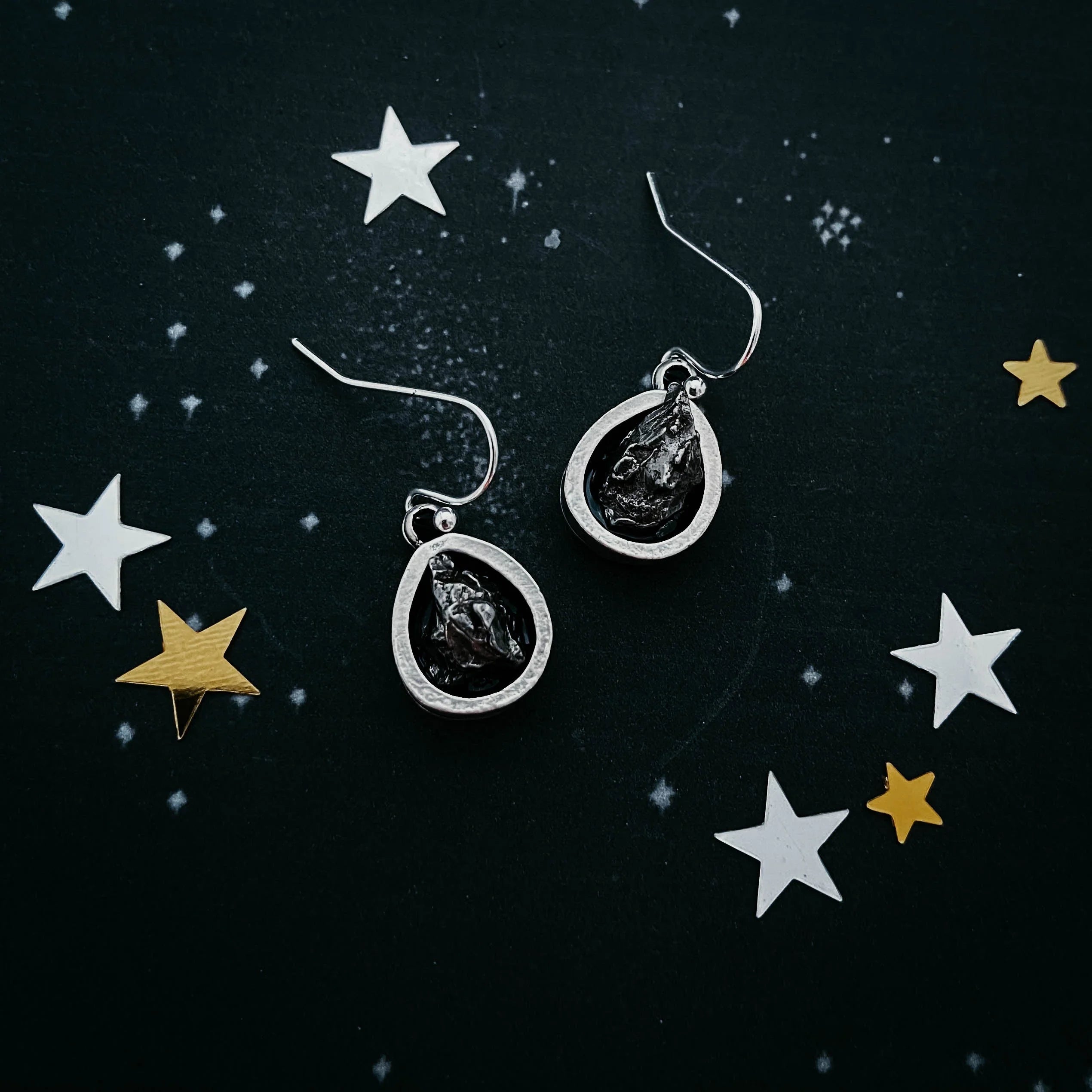 Teardrop cosmic earrings with black stones on starry background from Qu!rk Boutique