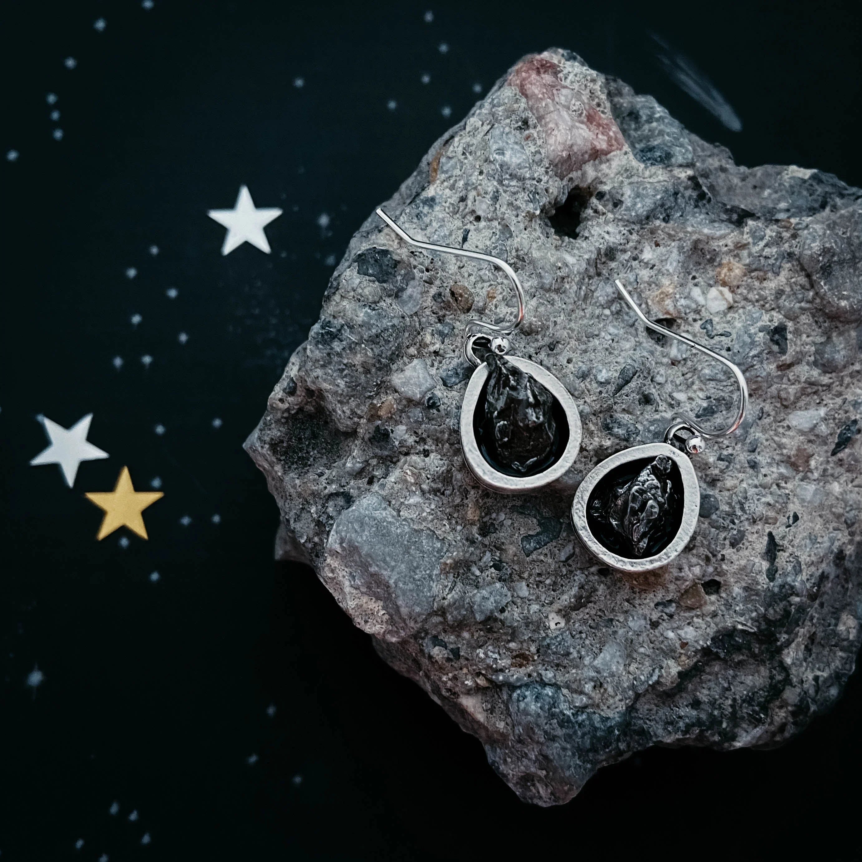 Cosmic teardrop earrings with black stones on stone slab, Qu!rk Boutique gift jewelry
