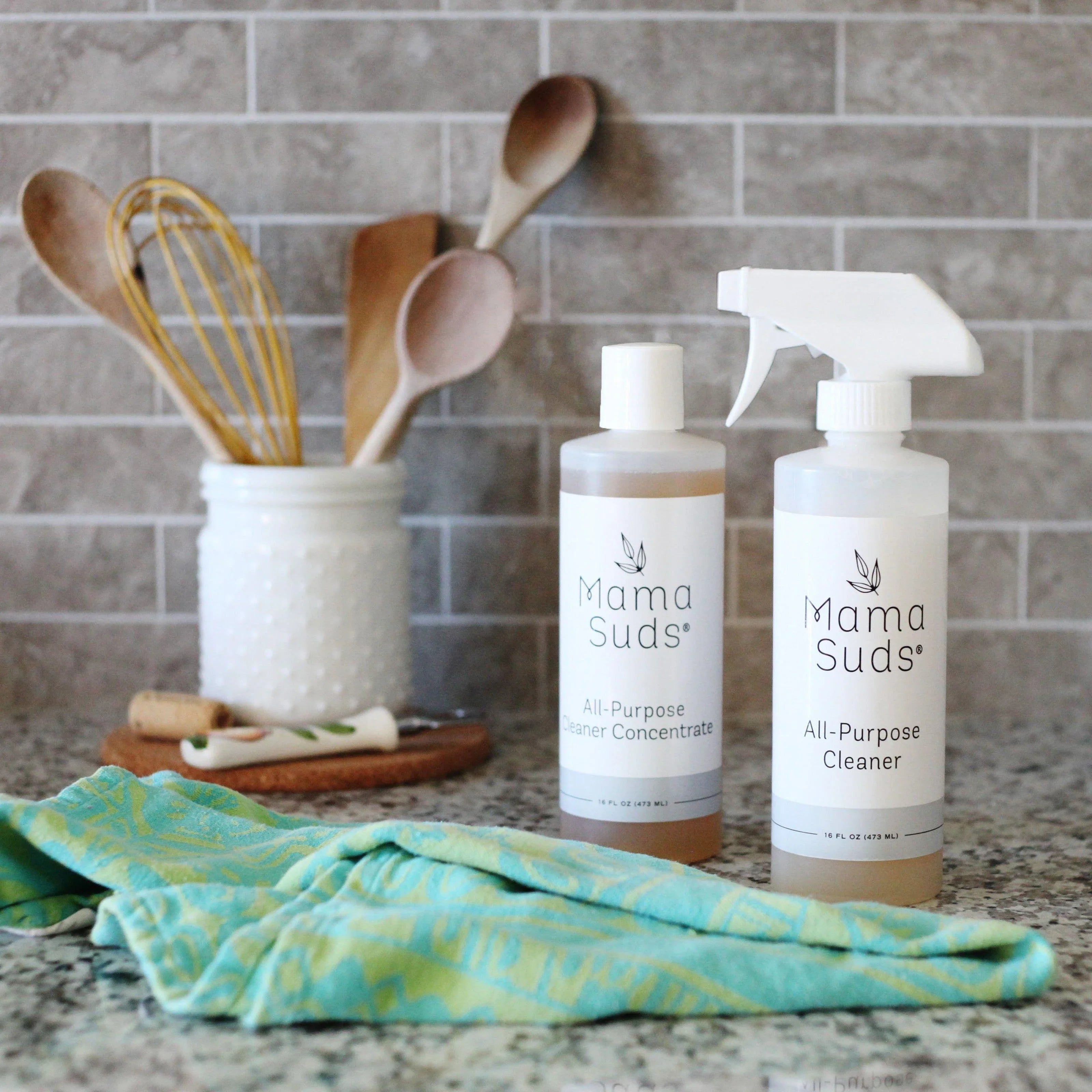 Mama Suds all-purpose cleaner bottles and cleaning cloth on kitchen counter at Qu!rk Boutique