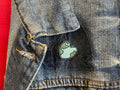 Eco-friendly enamel pin shaped like Earth on blue denim jacket at Qu!rk Boutique