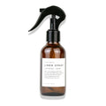 Brown glass bottle of Slow North linen spray with lavender mint scent and black spray nozzle