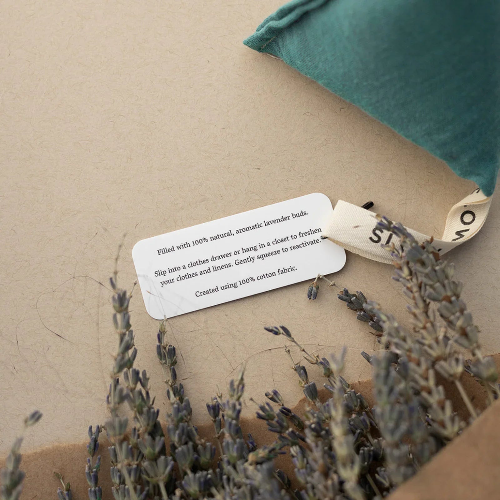 Lavender sachet with natural dried lavender buds and tag on beige surface