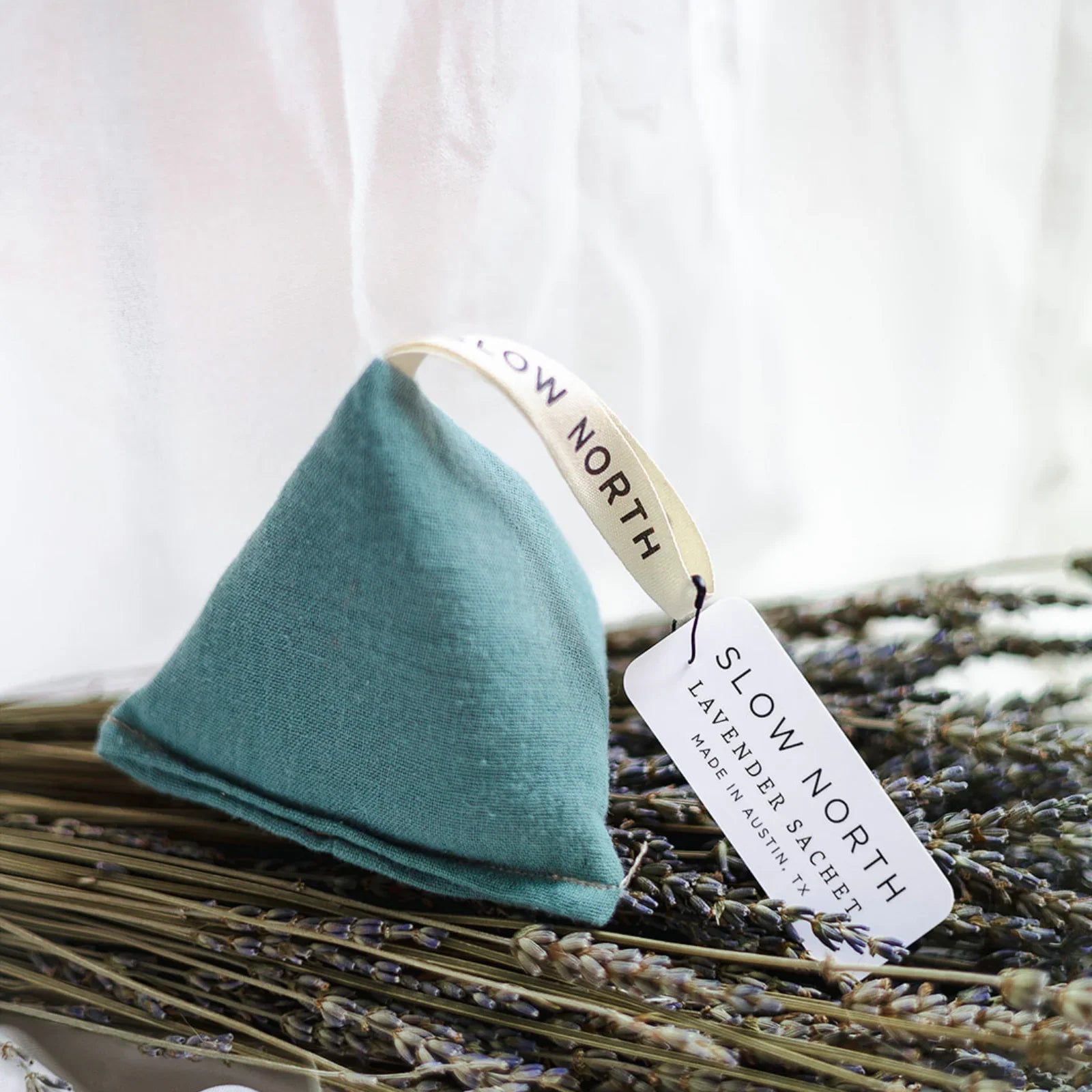 Lagoon blue pyramid-shaped lavender sachet with Slow North tag on dried lavender bundle