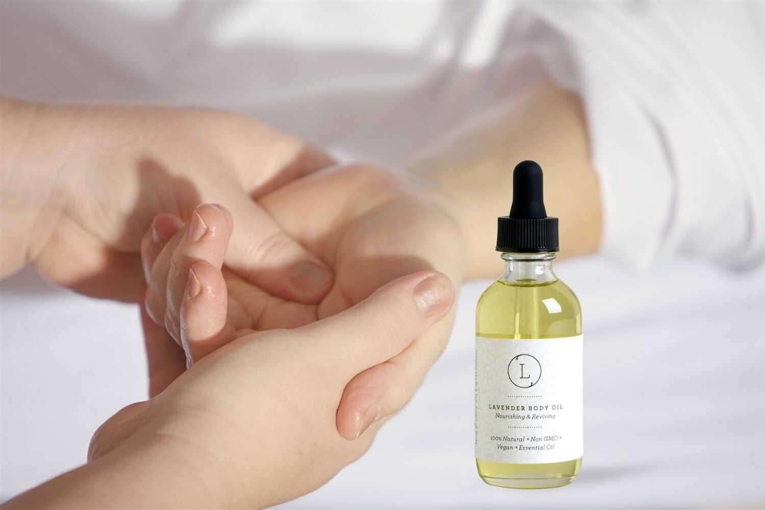 Person applying nourishing lavender body oil from a glass dropper bottle on their wrist