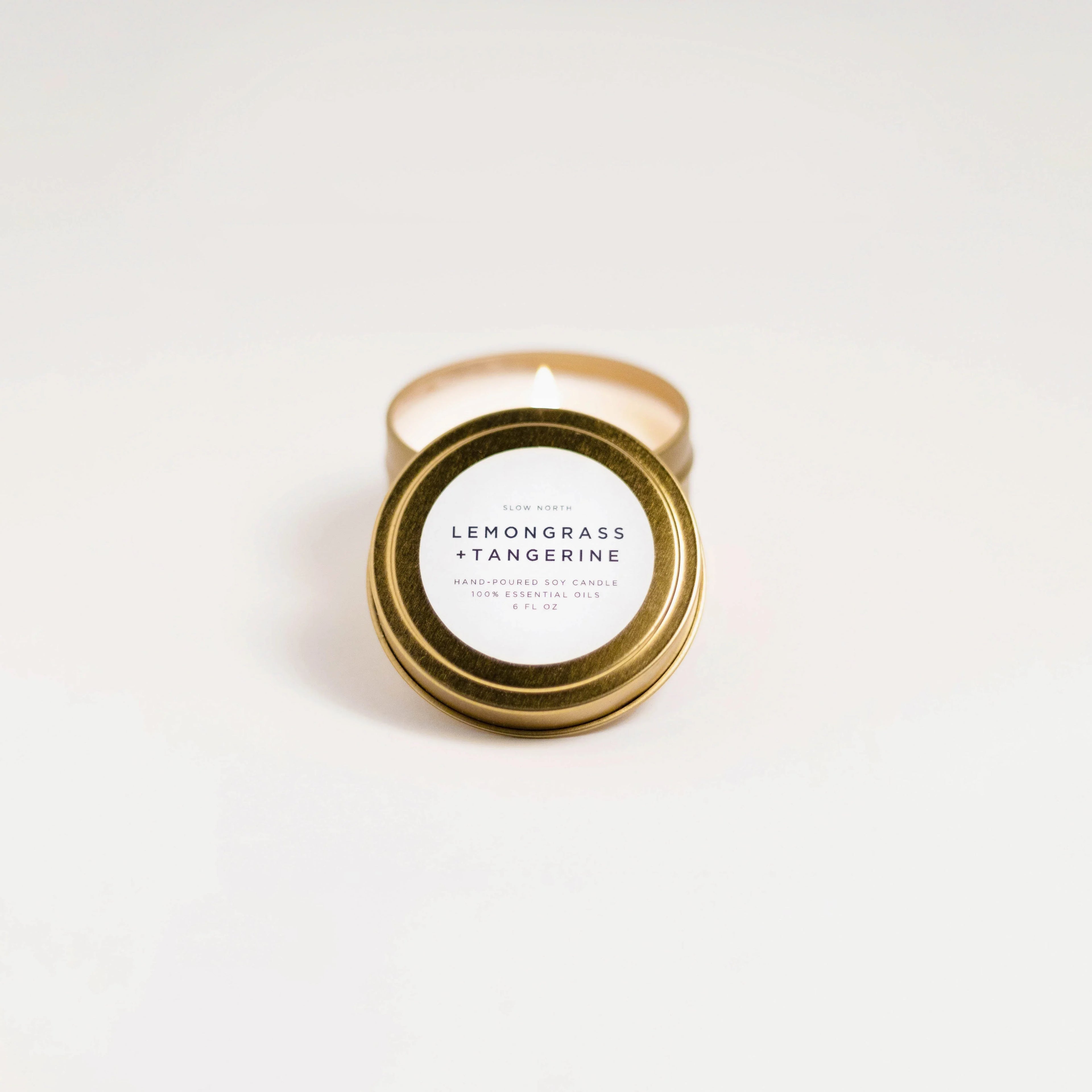 Slow North Lemongrass Tangerine travel tin soy candle with gold lid on white background
