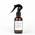 Slow North linen spray bottle labeled Hello Sunshine, amber glass, black spray top, white background