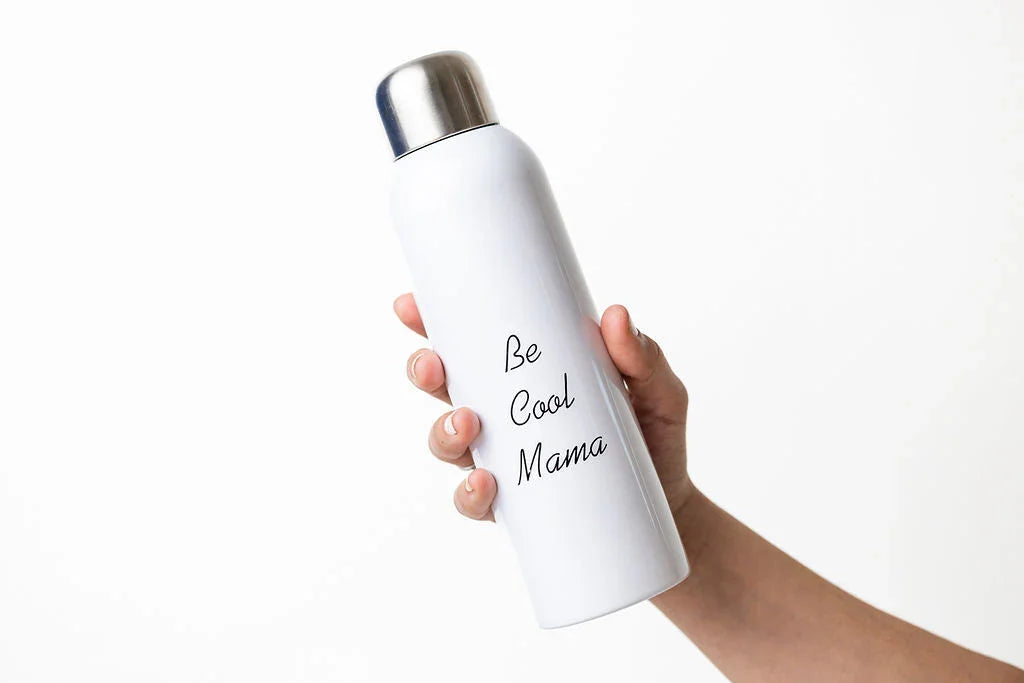 Hand holding white stainless steel water bottle with silver cap and 'Be Cool Mama' text