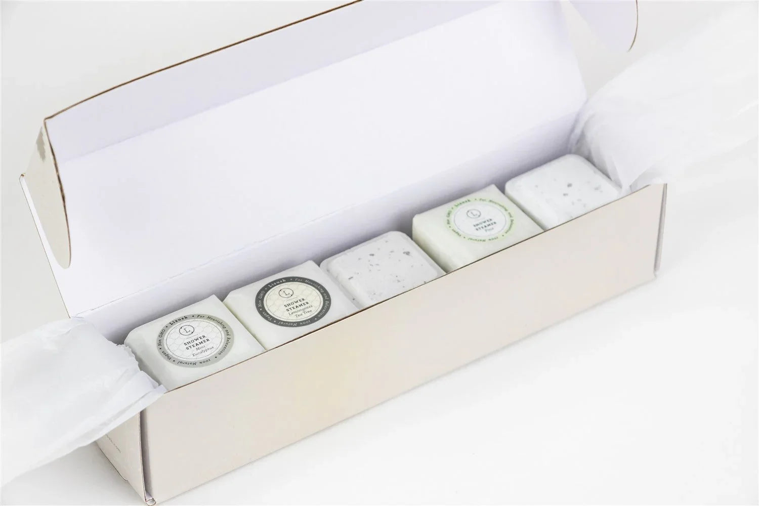 Open white box with five scented shower steamers for men labeled eucalyptus and tea tree