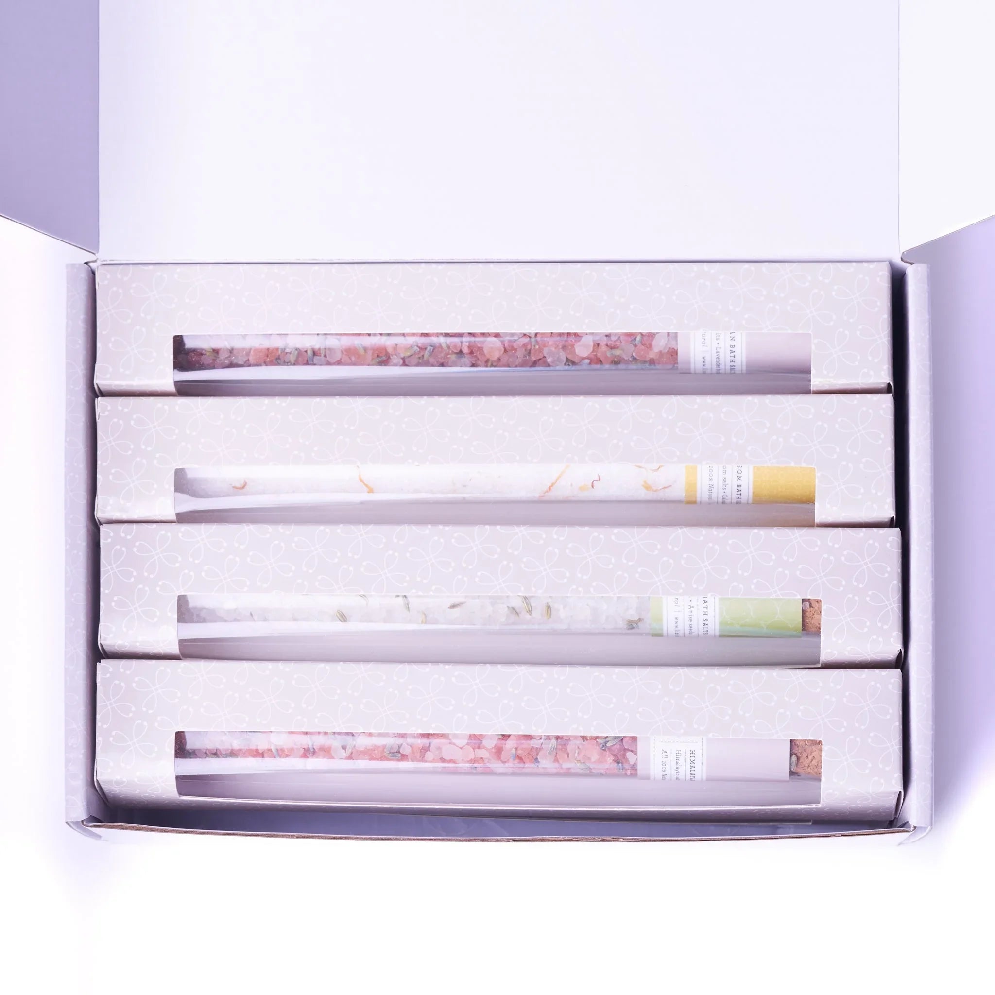 Set of four boxed bath salts in a white gift box with decorative patterns