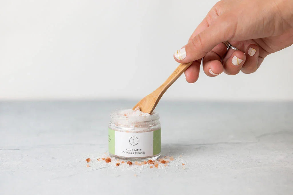 Hand scooping Lizush natural foot salts with wooden spoon at Qu!rk Boutique