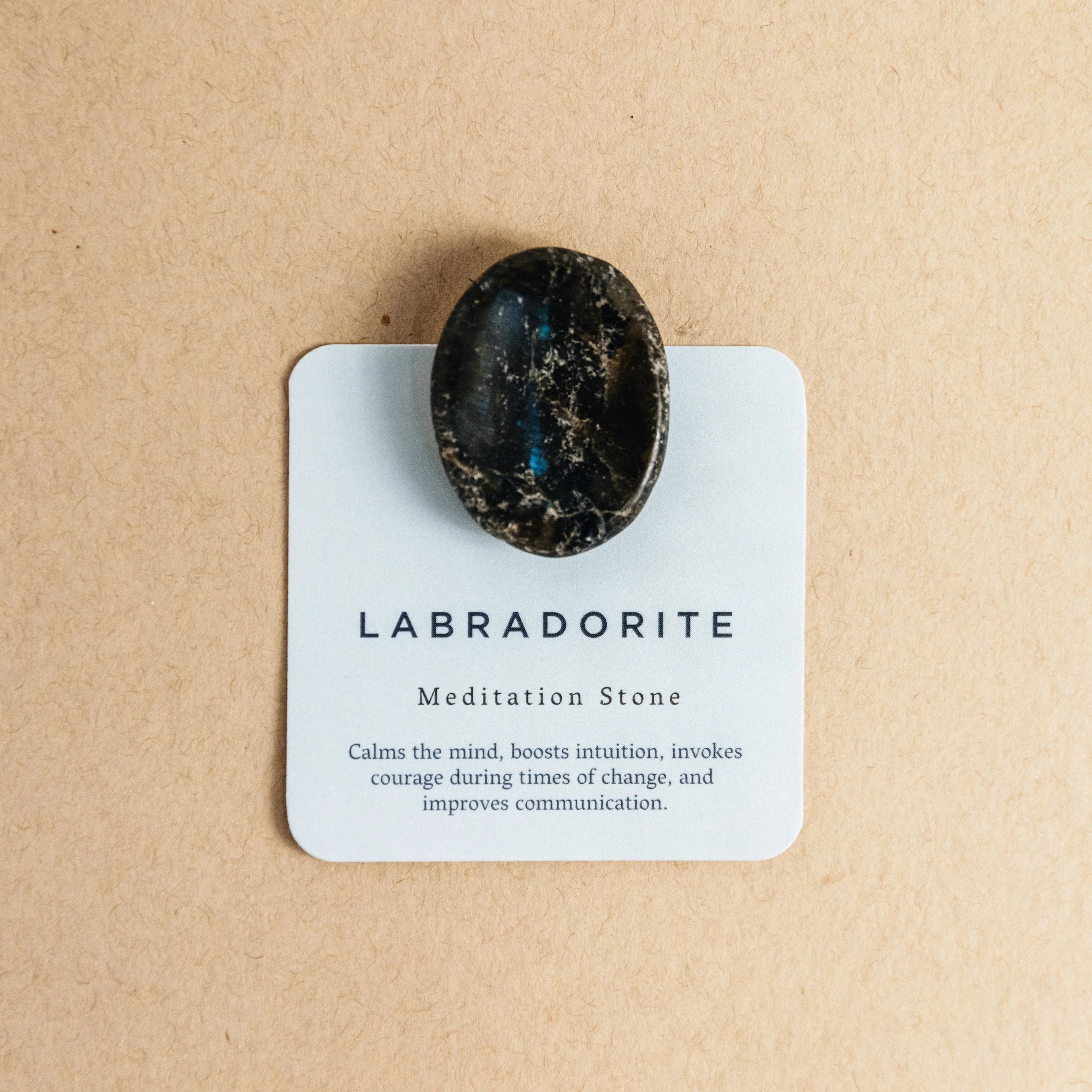 Polished labradorite meditation stone on card with calming and intuition-boosting properties