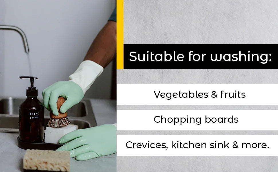 Person wearing green gloves washing with brush and dish soap at kitchen sink, suitable for fruits, chopping boards