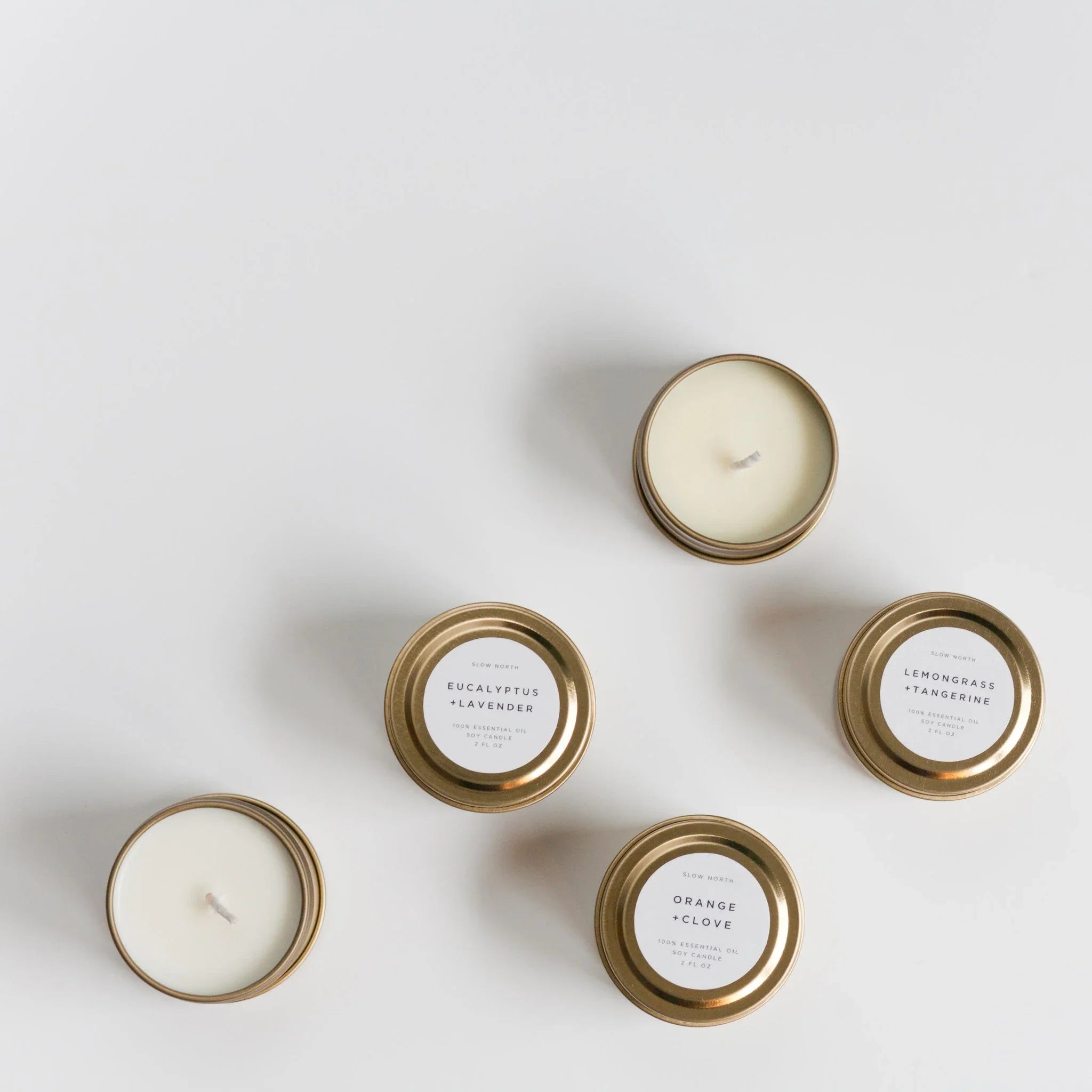 Set of small gold tin candles with eucalyptus, lavender, lemongrass, tangerine, orange, and clove scents