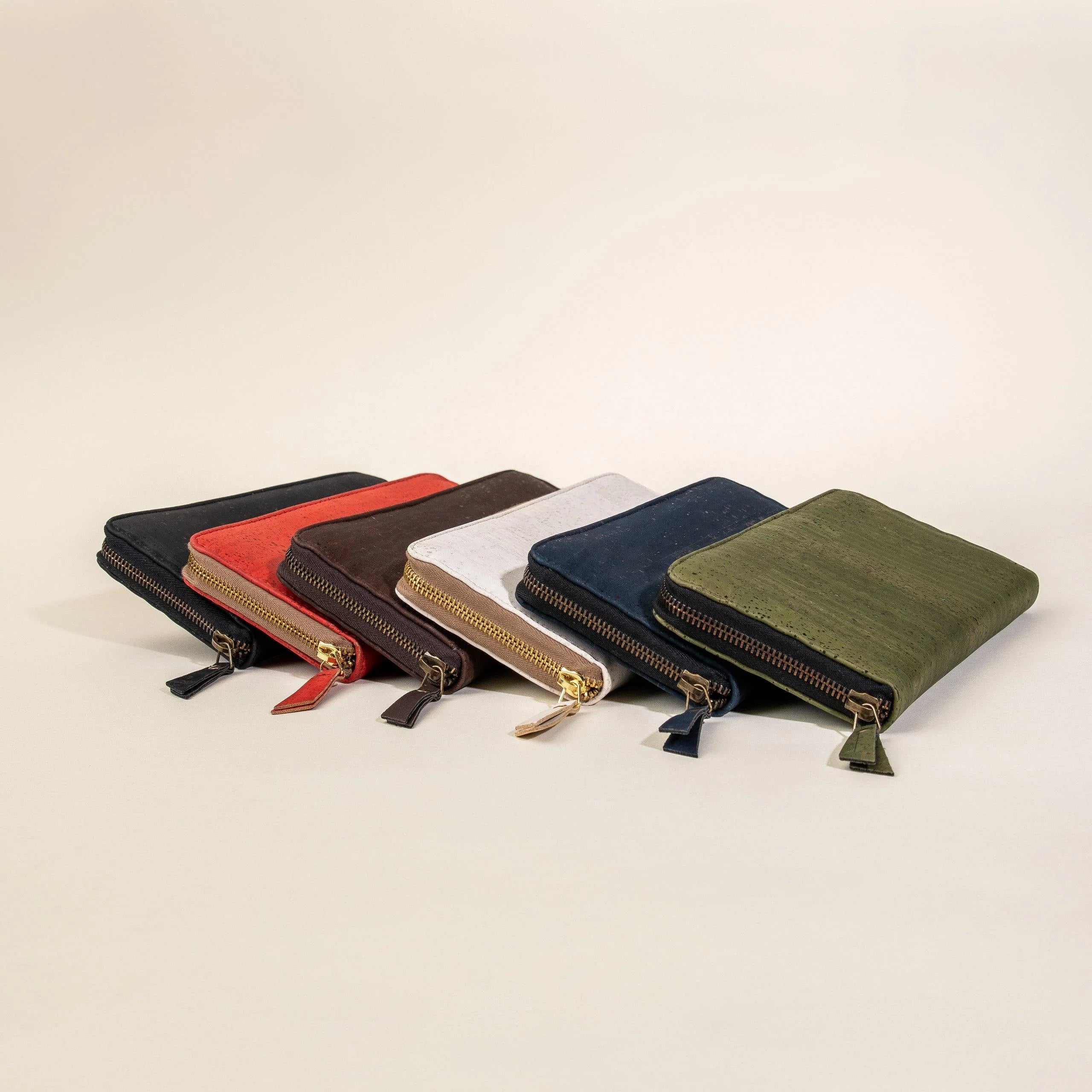 Colorful zippered wallets arranged in a row on neutral background, Qu!rk Boutique gift shop.