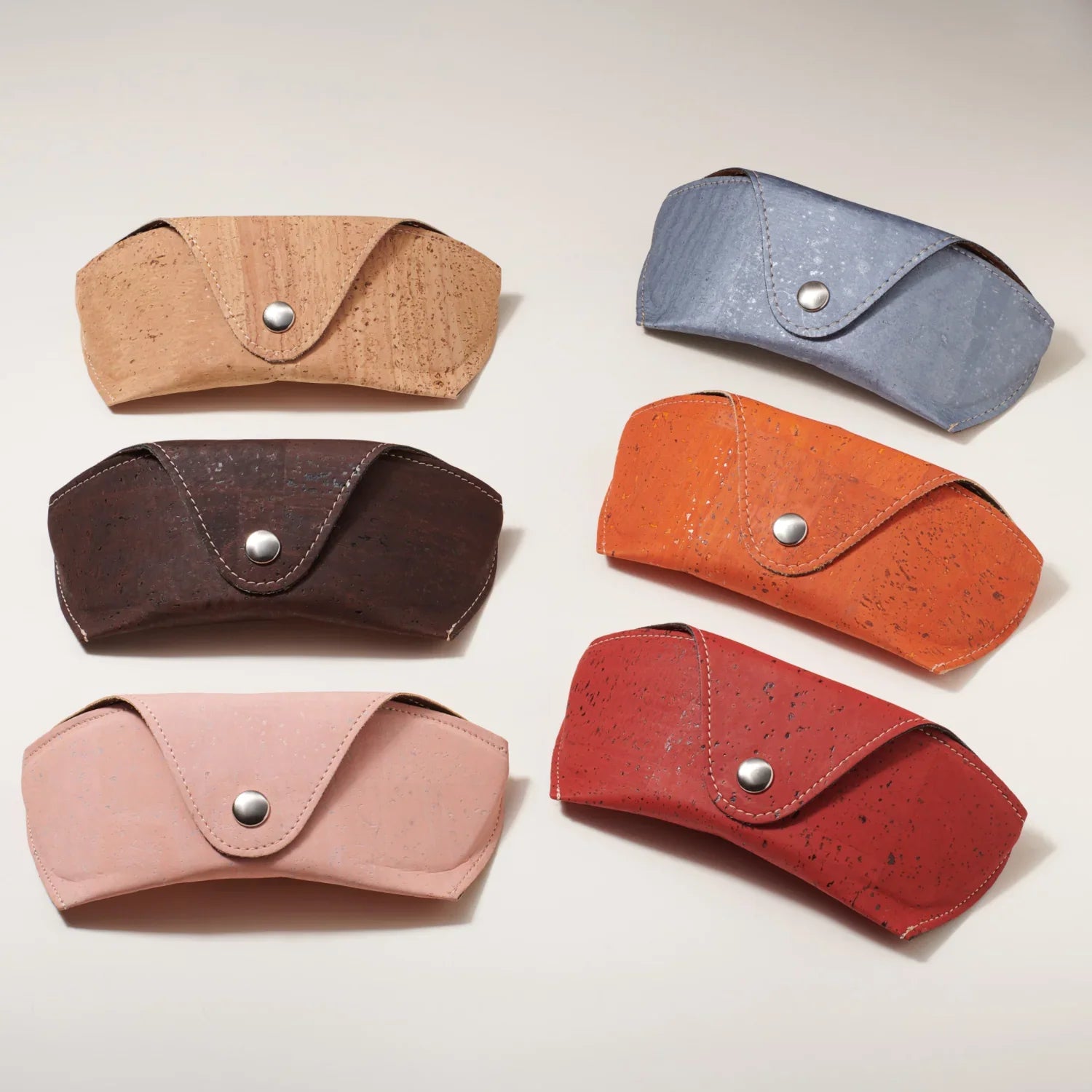 Six colorful, eco-friendly cork sunglasses cases from Qu!rk Boutique, arranged on a light background.