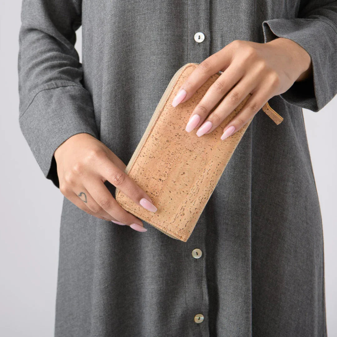 Woman in grey dress holding a natural cork wallet, Qu!rk Boutique eco-friendly accessory