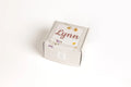 Personalized gift box with the name Lynn, decorated with dried flowers on light patterned background