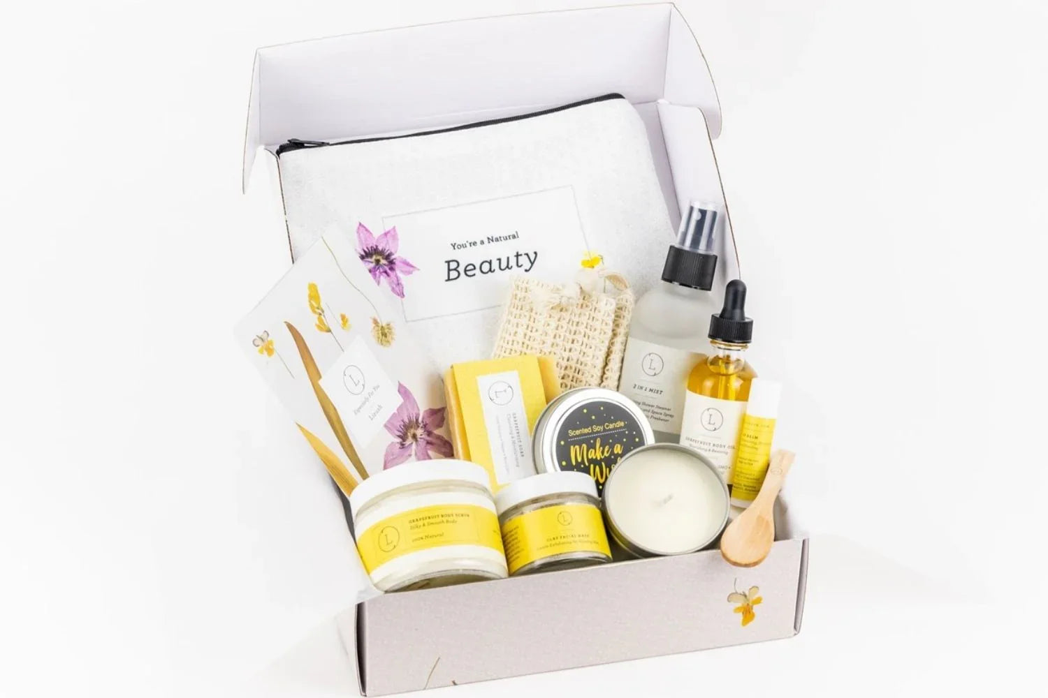 Natural citrus skincare gift box with body scrub, balm, oil, mist, candle, and pouch