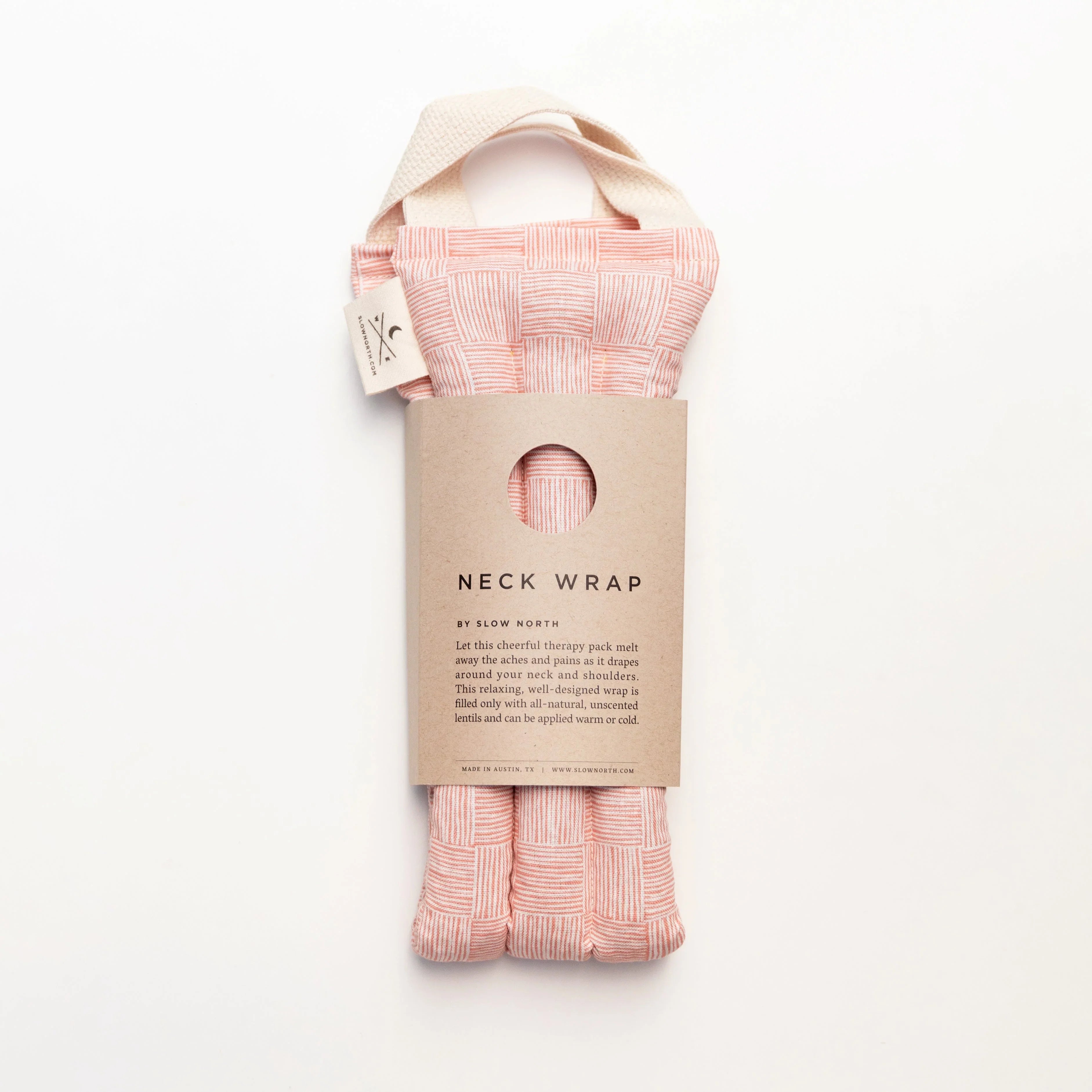 Pink patterned fabric neck wrap with beige handle and kraft paper label by Slow North