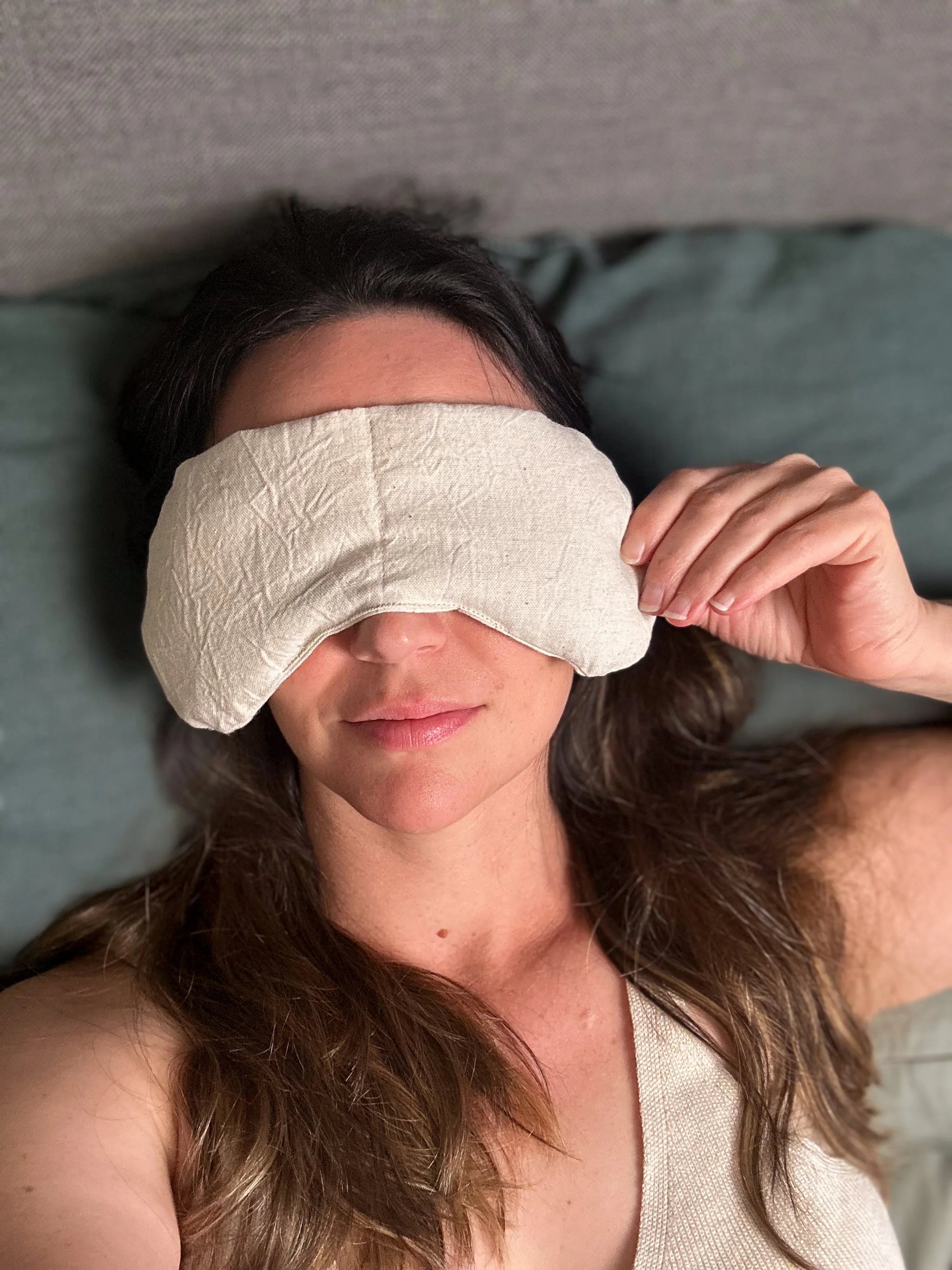 Woman relaxing with a natural fabric eye mask, showcasing Qu!rk Boutique's wellness accessory