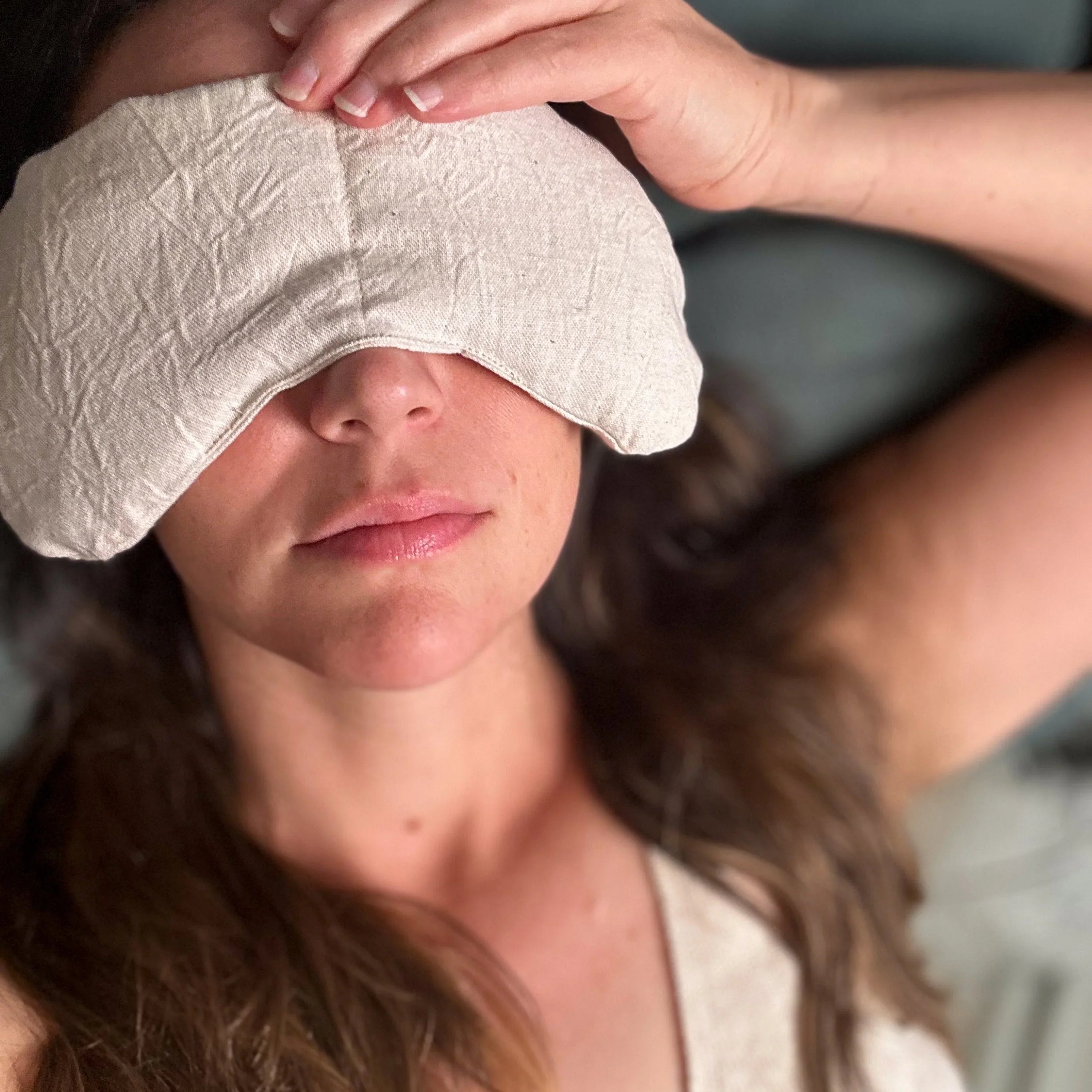 Woman relaxing with a natural linen therapy eye mask from Qu!rk Boutique
