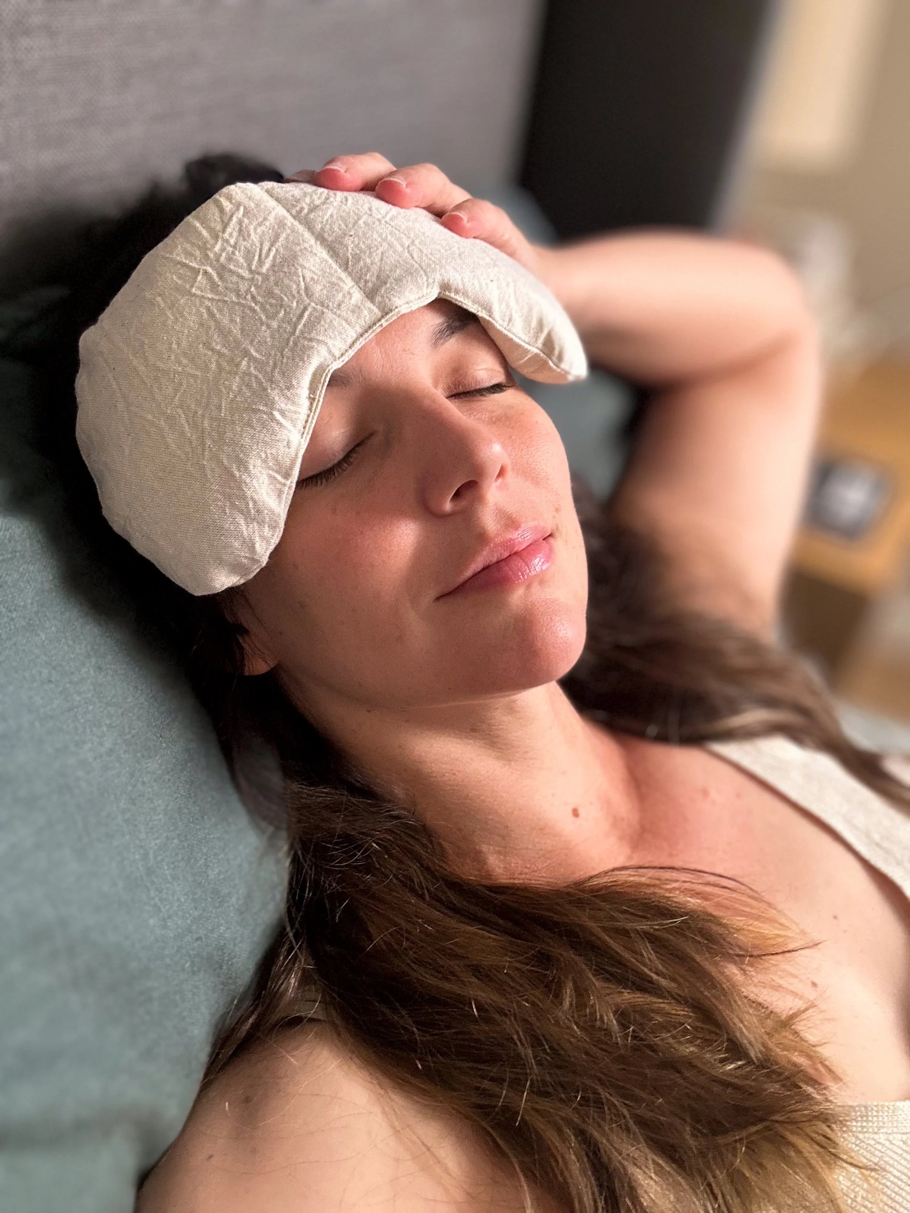Woman relaxing with a natural therapy eye mask, showcasing Qu!rk Boutique's wellness gift.