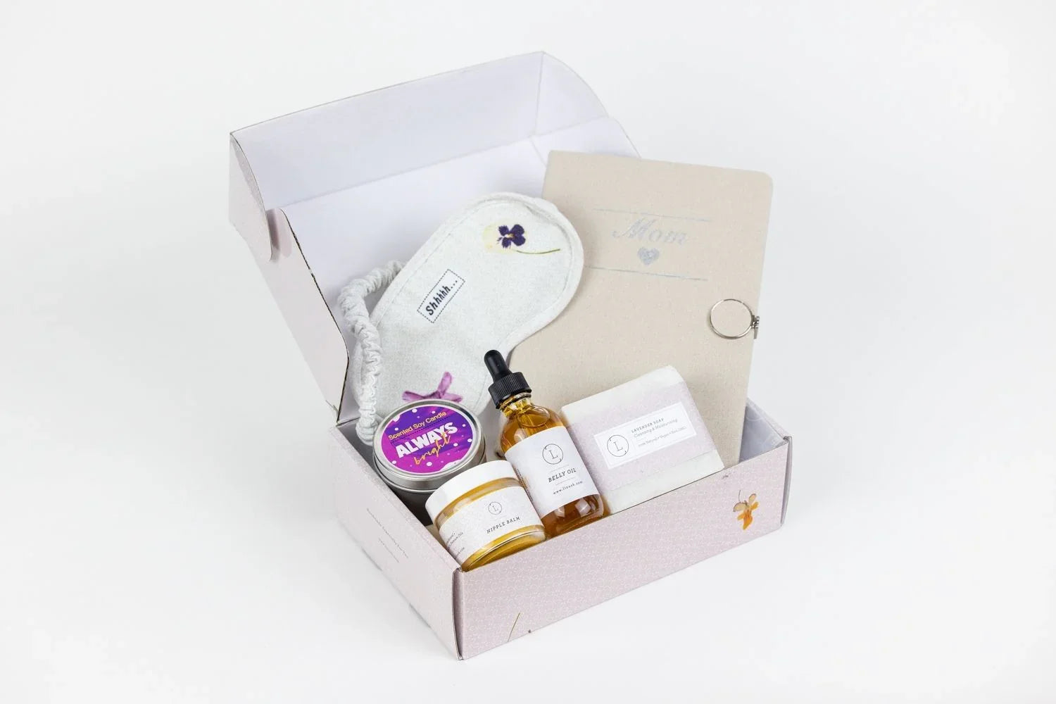 New mom gift box with eye mask, scented soy candle, belly oil, nipple balm, lavender soap, and Mom journal