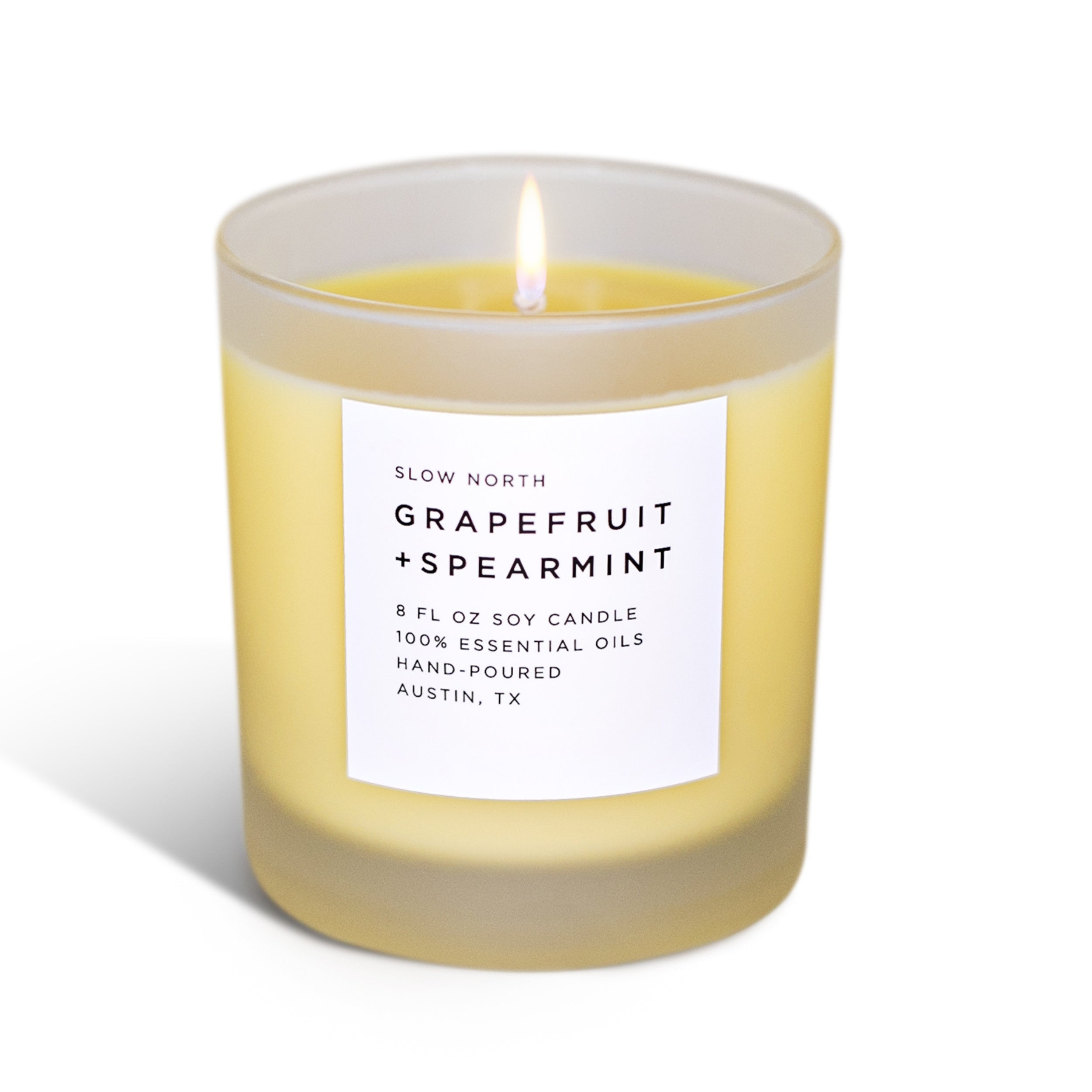 Lit grapefruit and spearmint scented soy candle in frosted glass jar by Slow North