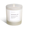 Frosted glass non-toxic soy candle labeled Shangri-La, hand-poured, on white background.