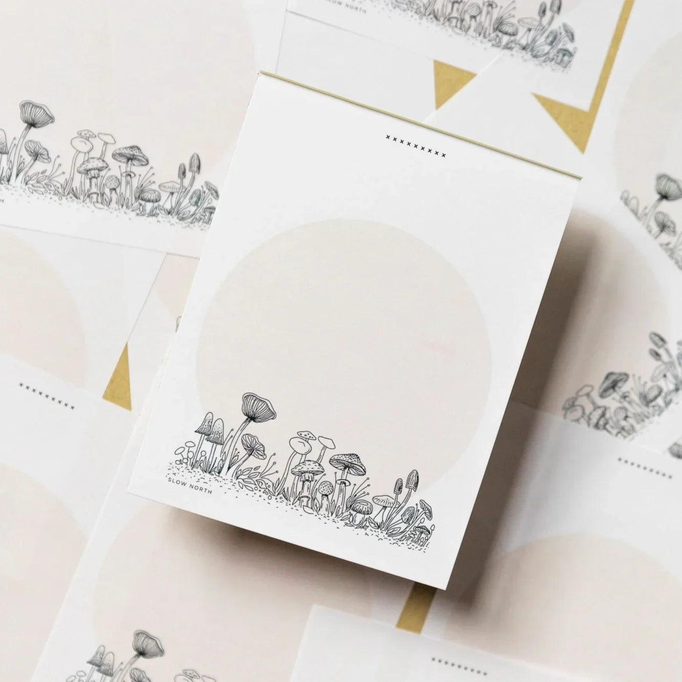 Notepad with black and white wild mushroom illustrations and soft beige circle background