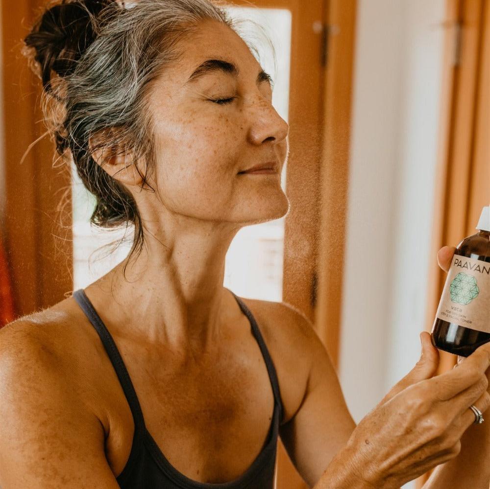 Woman misting face with PAAVANI Ayurveda spray in natural light at Qu!rk Boutique