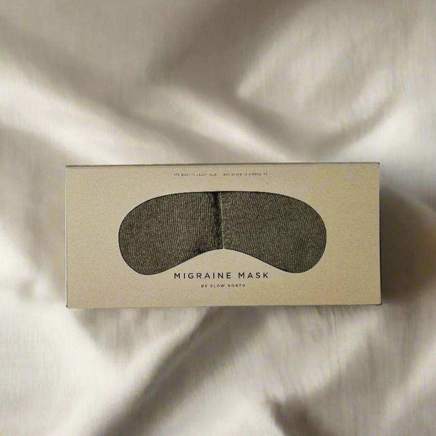 Eco-friendly migraine mask by Slow North in textured beige box on soft fabric background