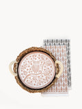 Round ceramic plate with owl and star design in woven basket on patterned cloths