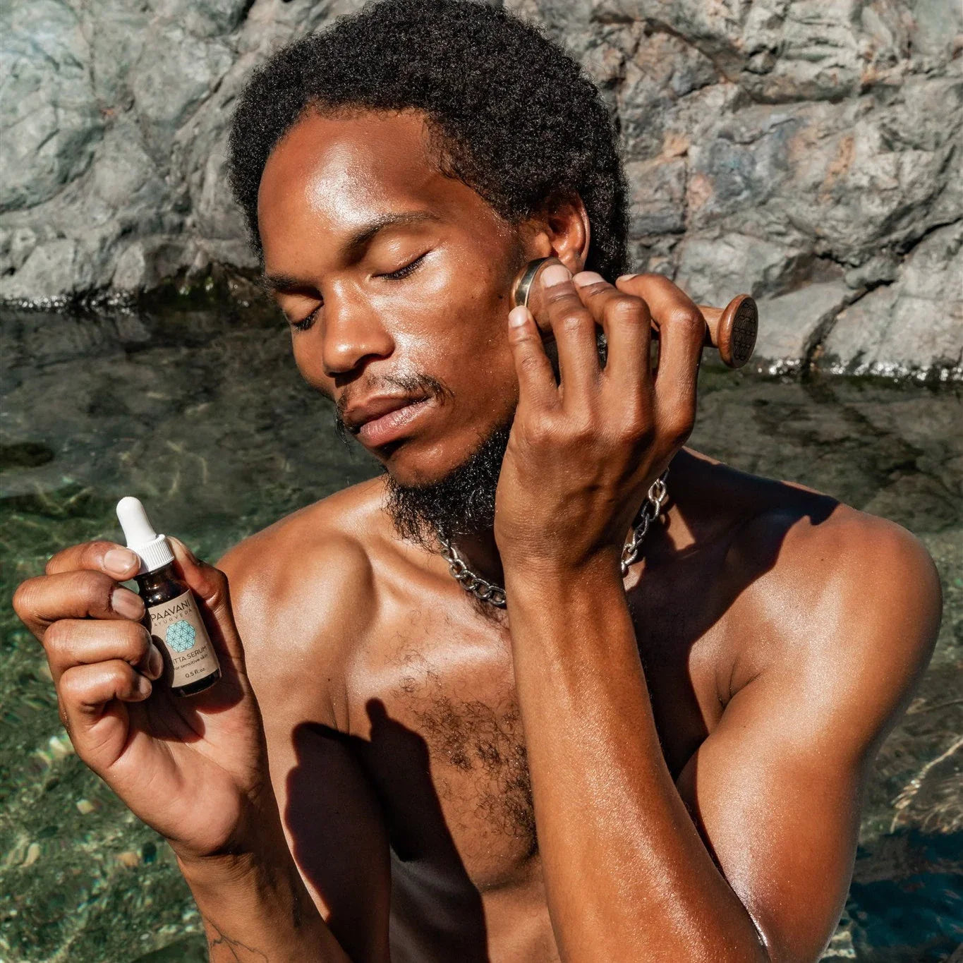 Man outdoors using PAAVANI facial oil and massage tool, natural skincare, Qu!rk Boutique