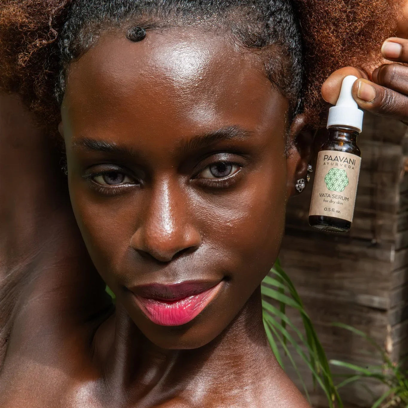 Woman with glowing skin holding Paavani Ayurveda Vata Serum, eco-friendly skincare at Qu!rk Boutique