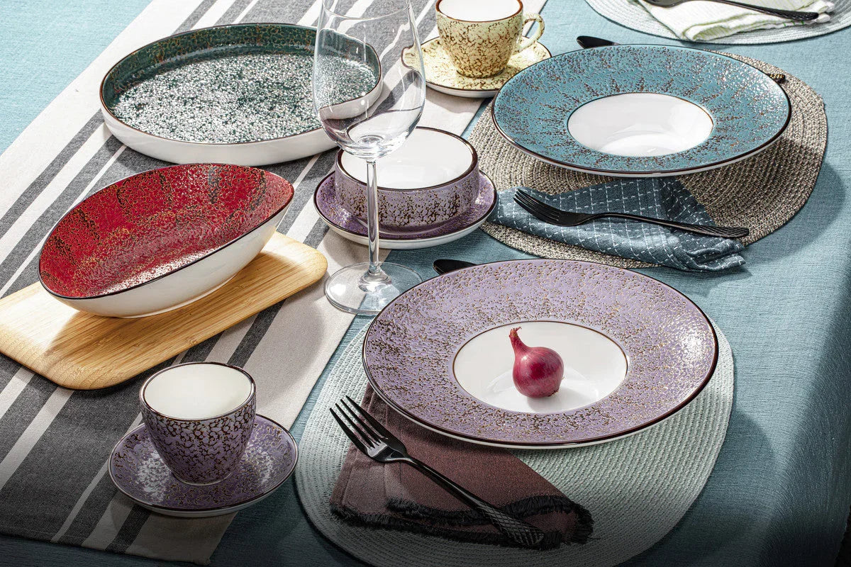 Colorful artist-designed ceramic plates, bowls, and cups on a modern table setting at Qu!rk Boutique