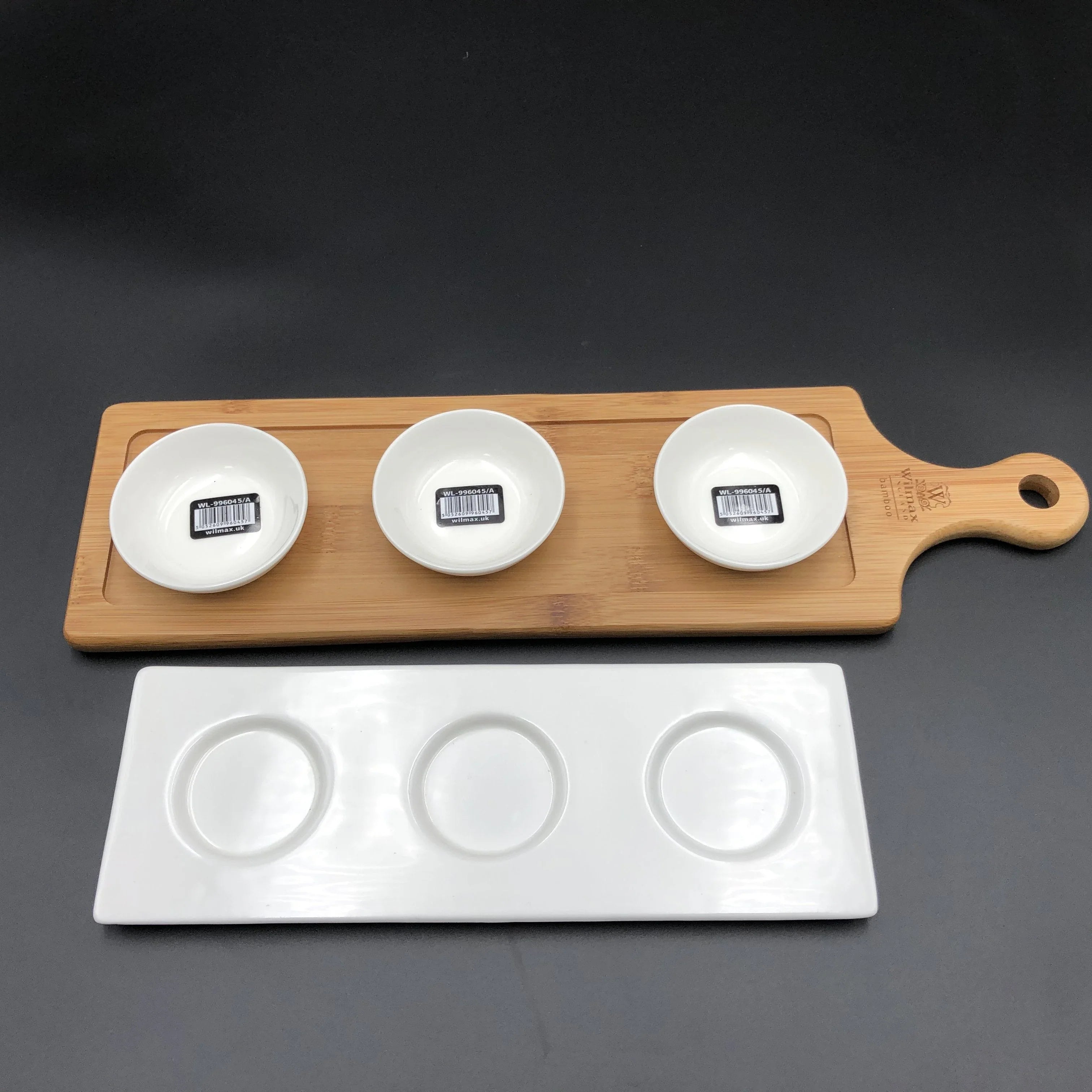 Three white ceramic bowls on bamboo serving board and white ceramic tray with three circular indentations