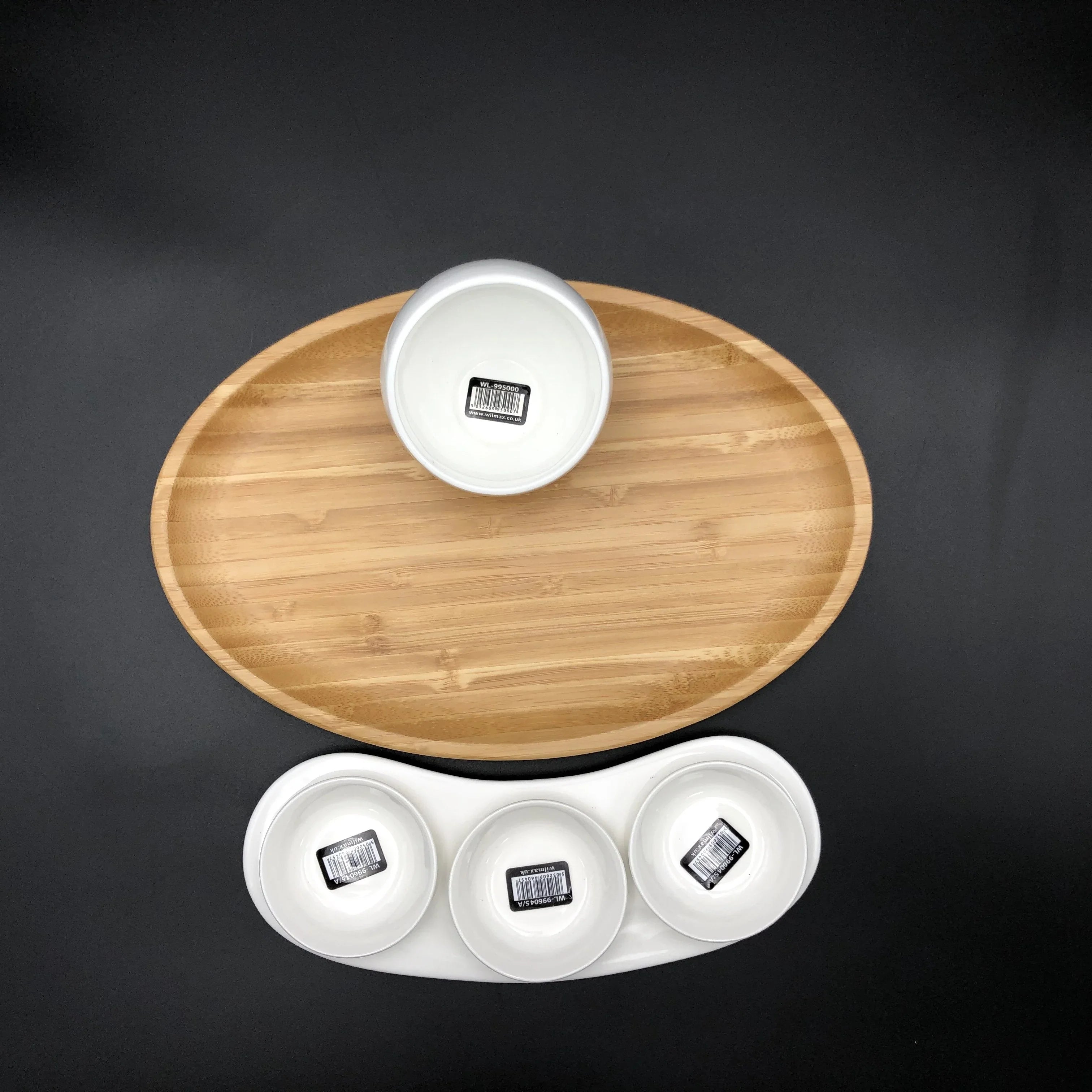 Oval bamboo serving tray with four white ceramic bowls on black background at Qu!rk Boutique.