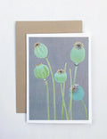 Greeting card with painted green poppy pods on gray background and brown envelope