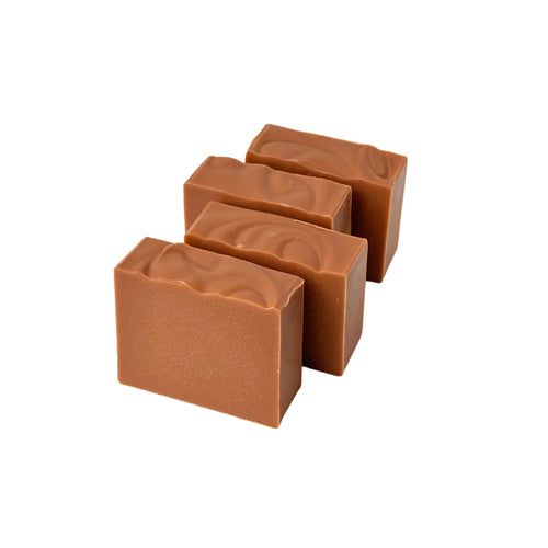 Four rectangular brown handmade soap bars with a smooth top surface on a white background