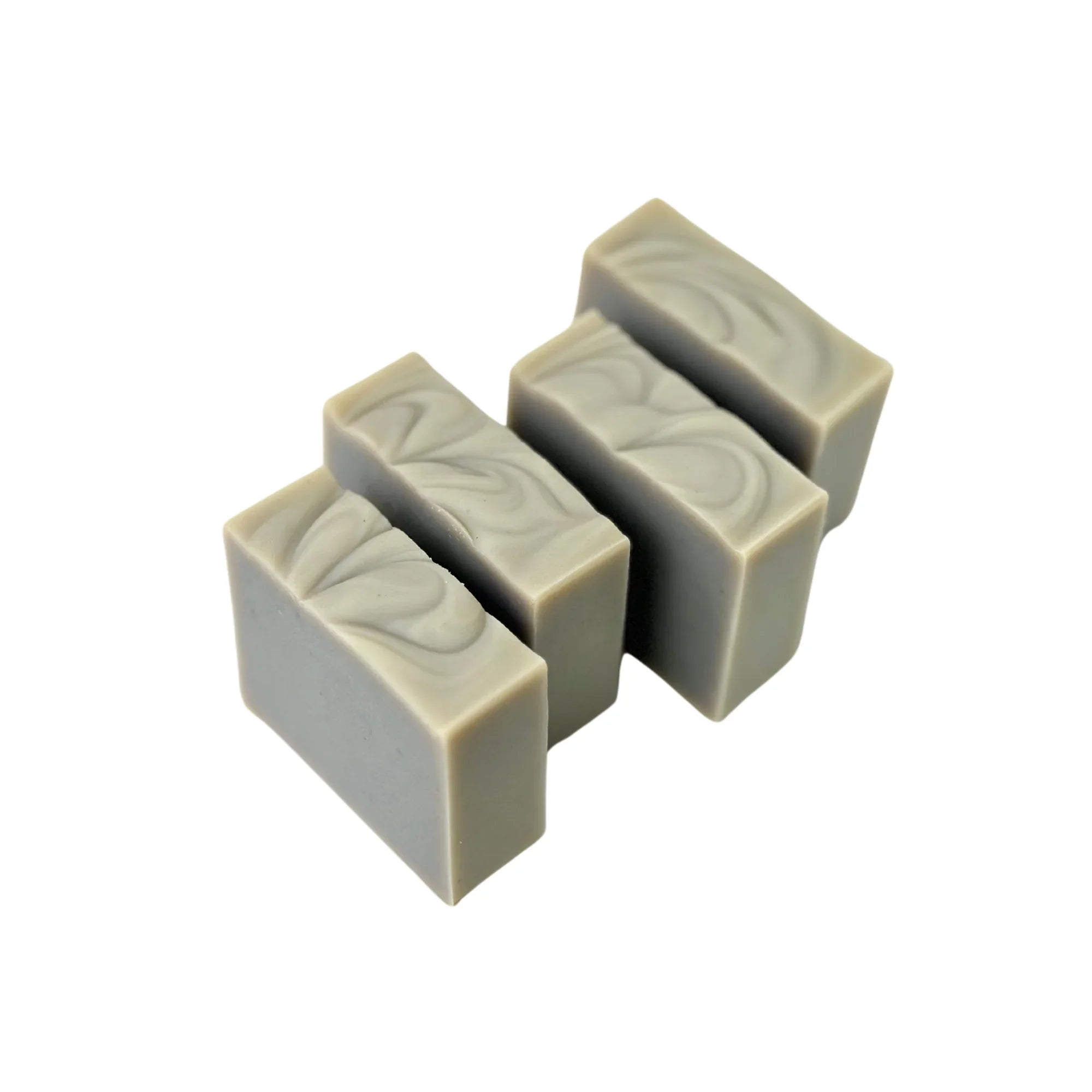 Three gray handmade soap bars with decorative swirls on top, isolated on white background