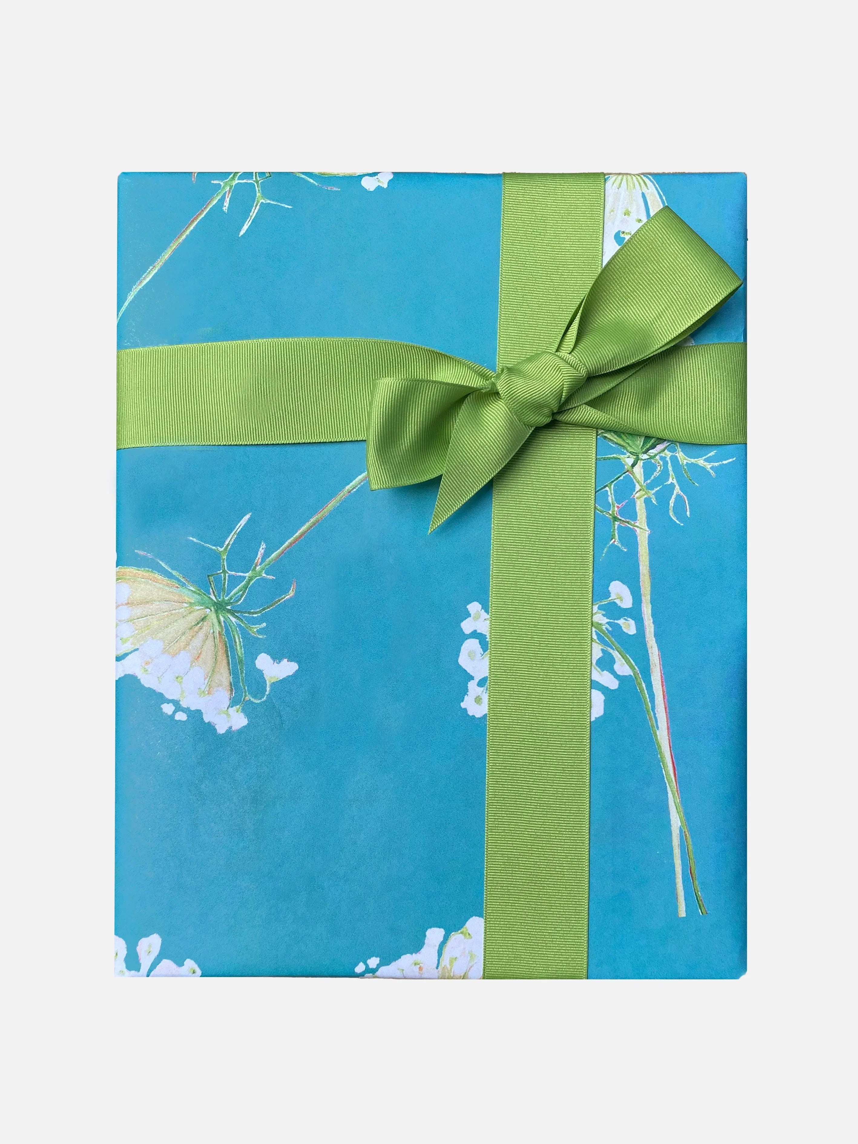 Gift box wrapped in blue Queen Anne's lace floral paper with a green ribbon bow
