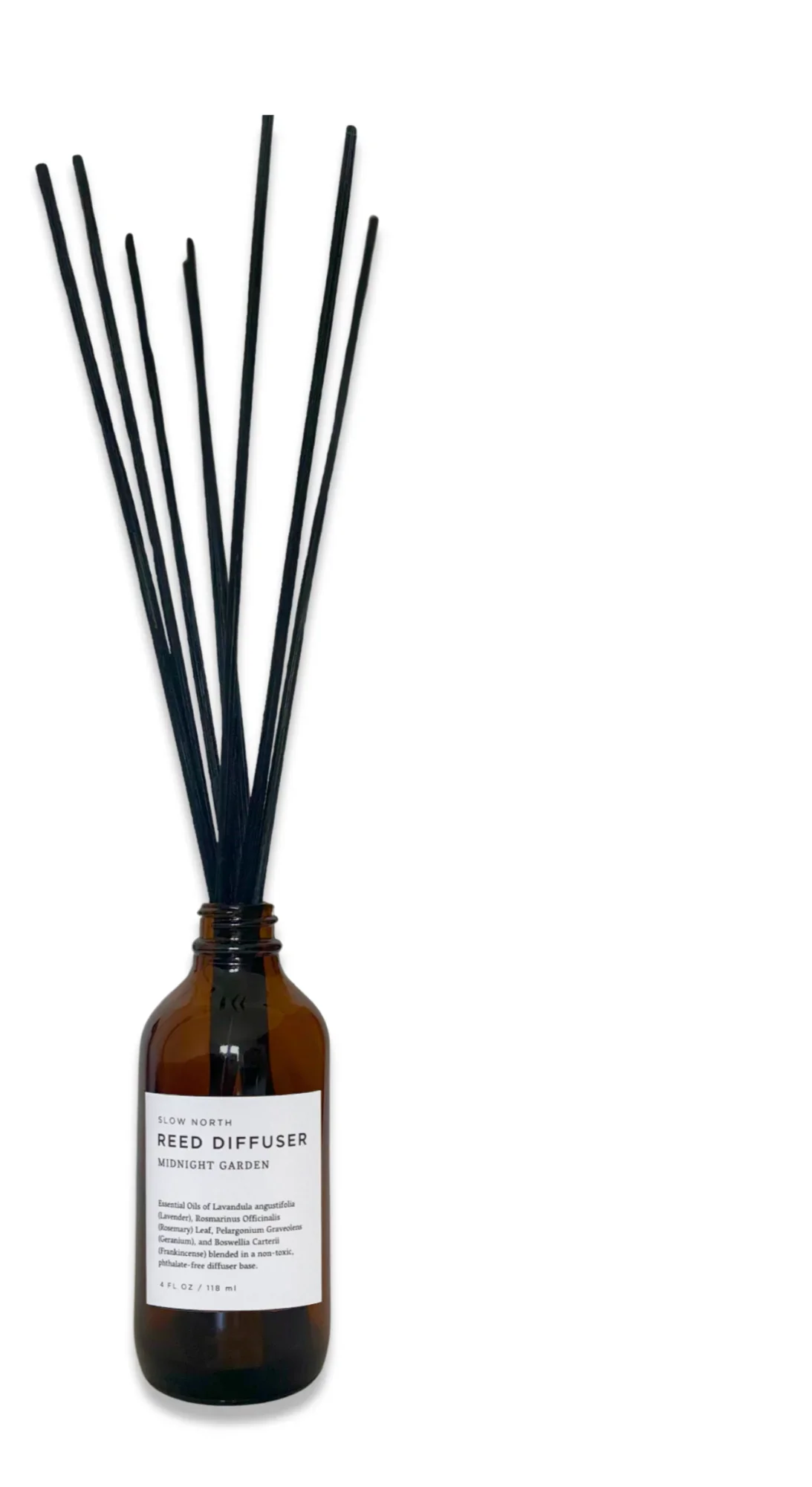 Slow North Midnight Garden reed diffuser with black reeds in amber glass bottle
