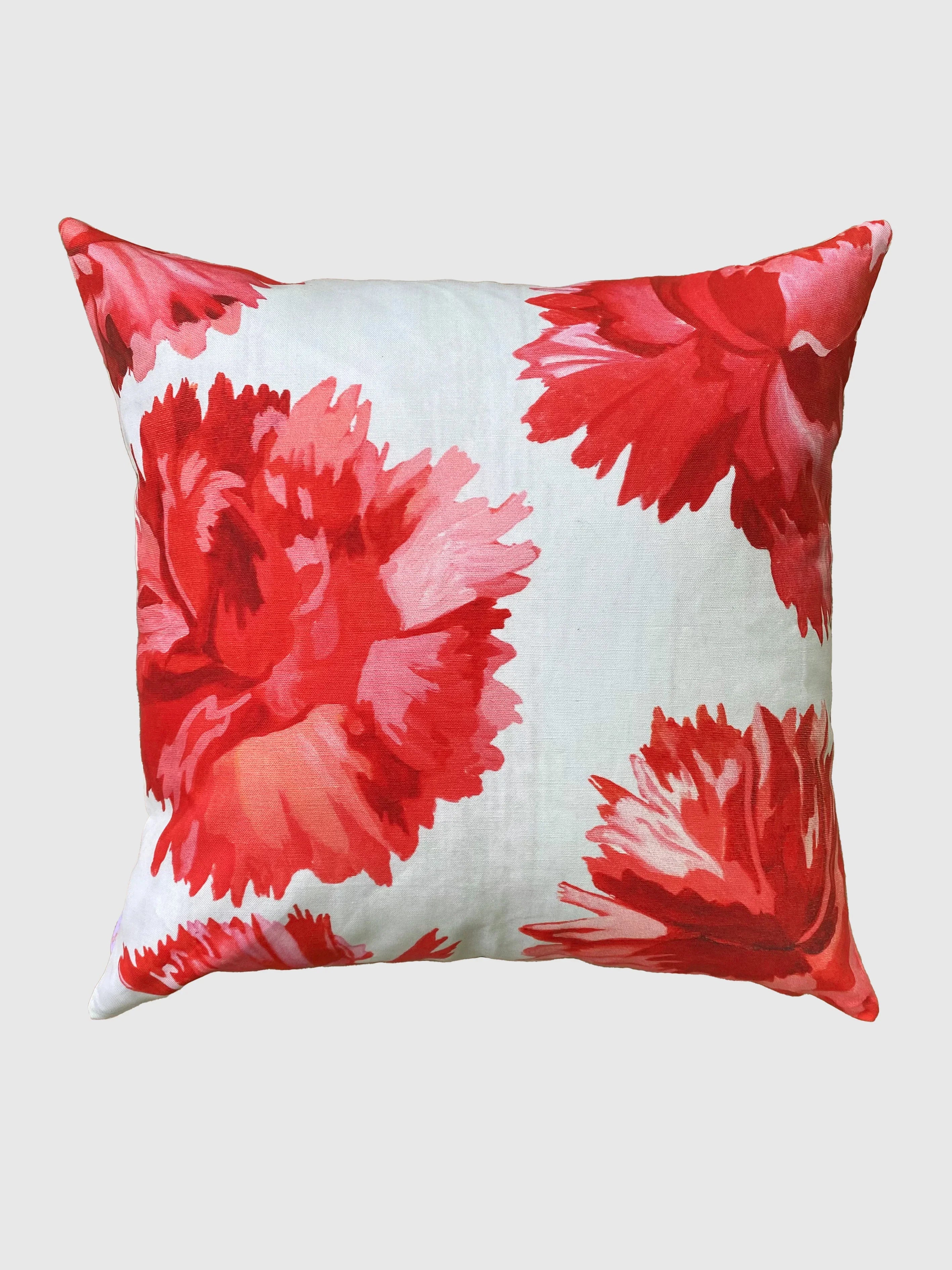 Throw pillow with large red and pink carnation floral pattern on white background