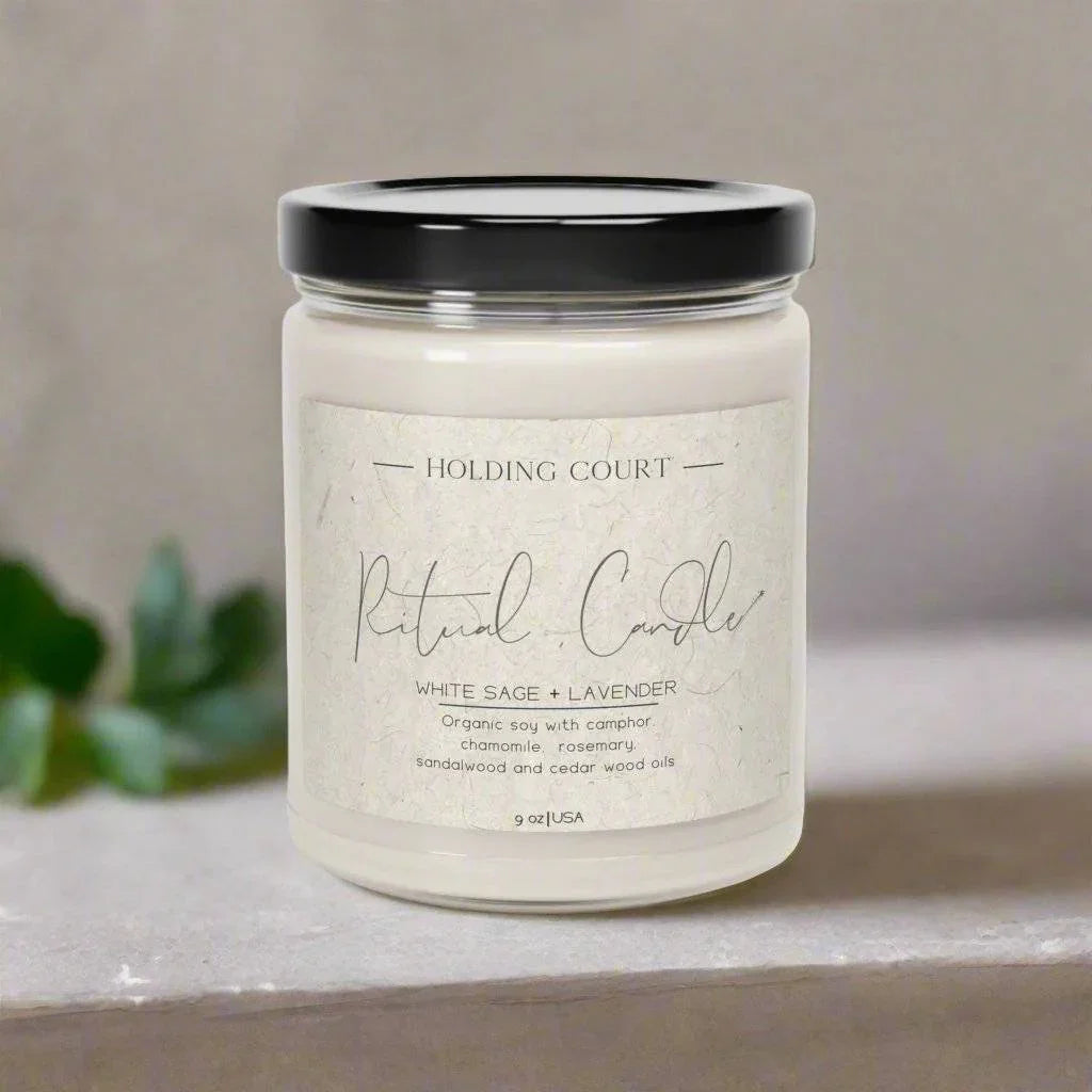 Holding Court Ritual Candle in glass jar with black lid, white sage and lavender scent