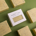 Rosemary and lemon natural bar soap bars and packaged soap on green background