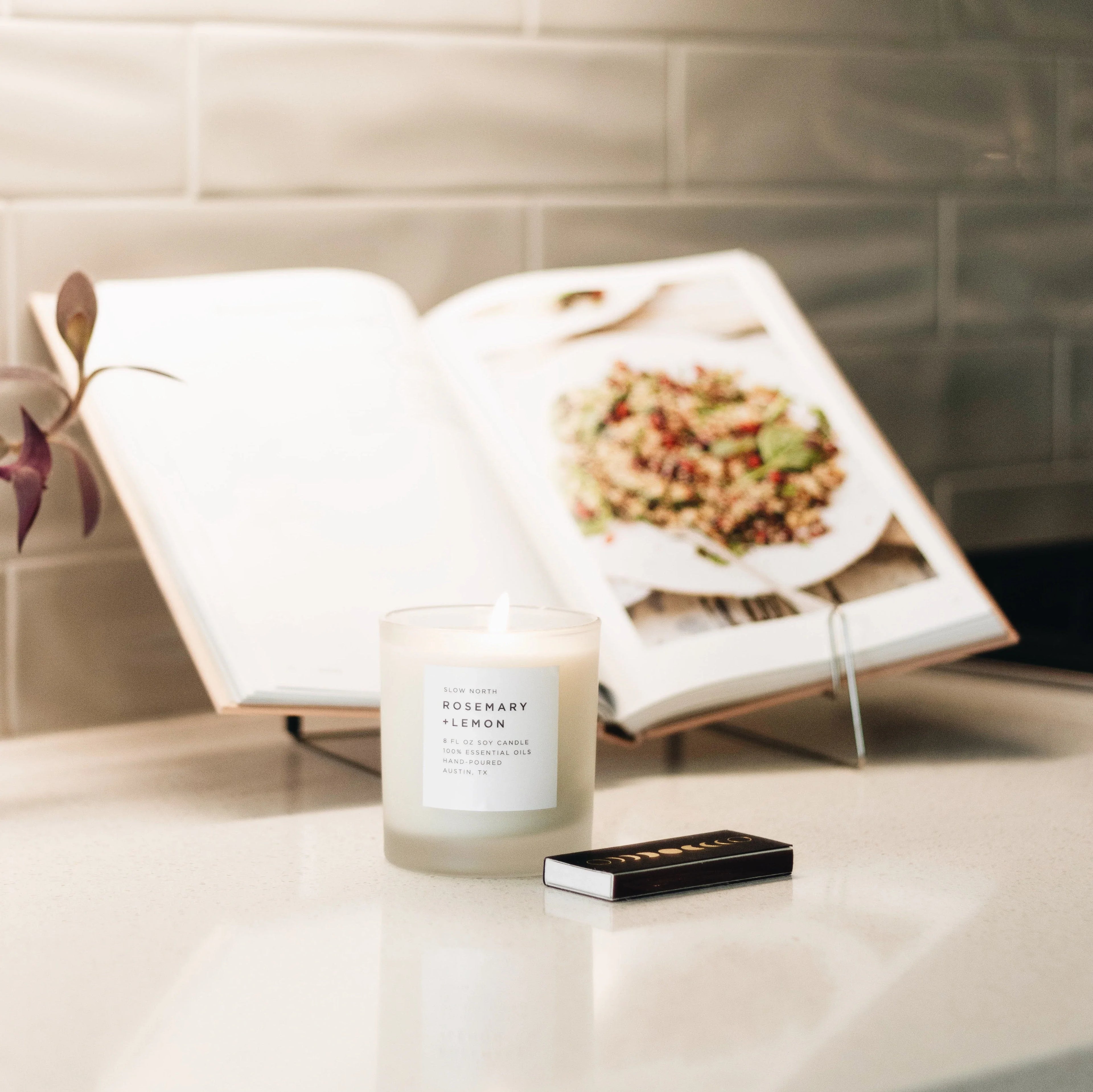 Rosemary Lemon soy candle by Slow North on kitchen counter with cookbook and matches, Qu!rk Boutique