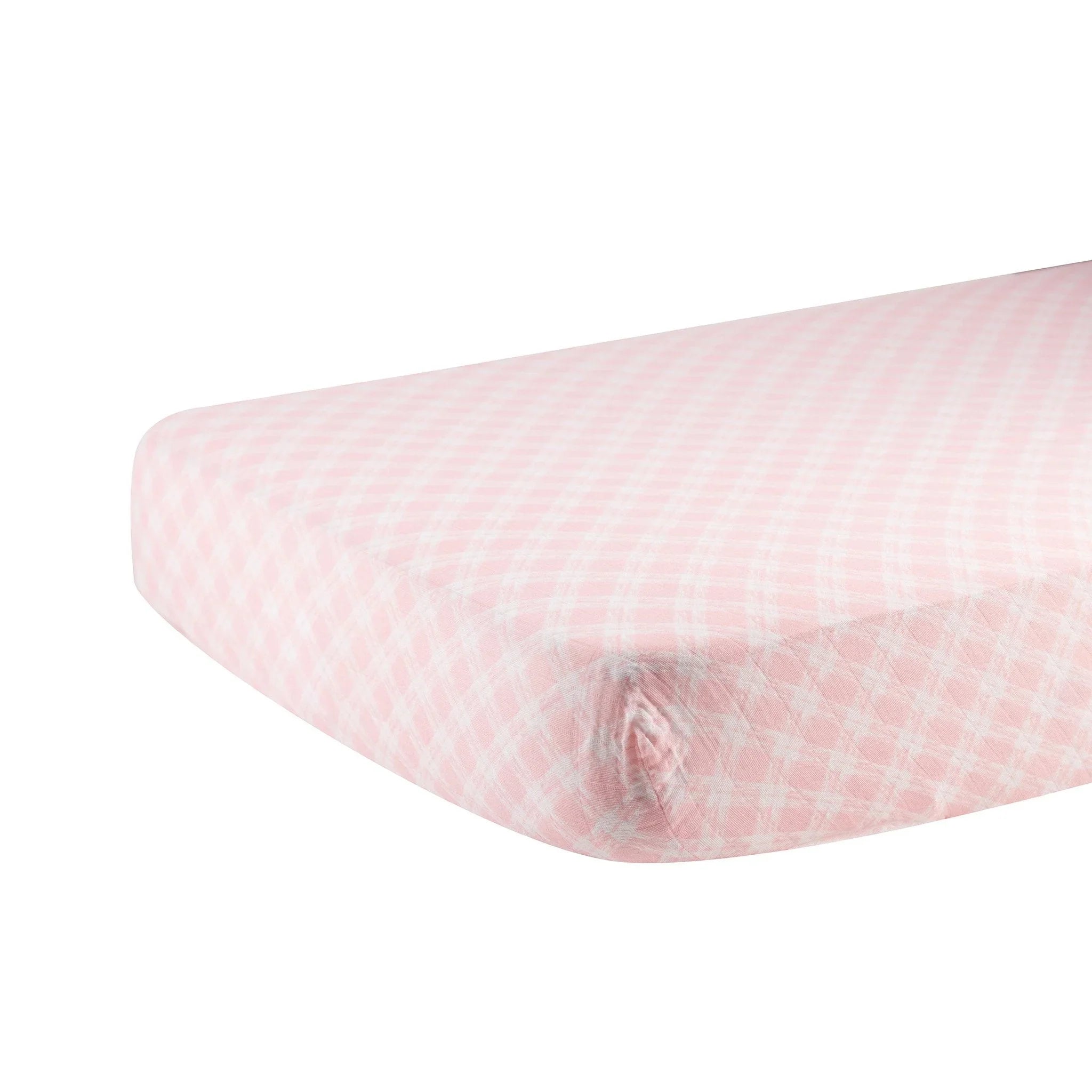 Primrose pink plaid cotton crib sheet with white grid pattern on mattress corner