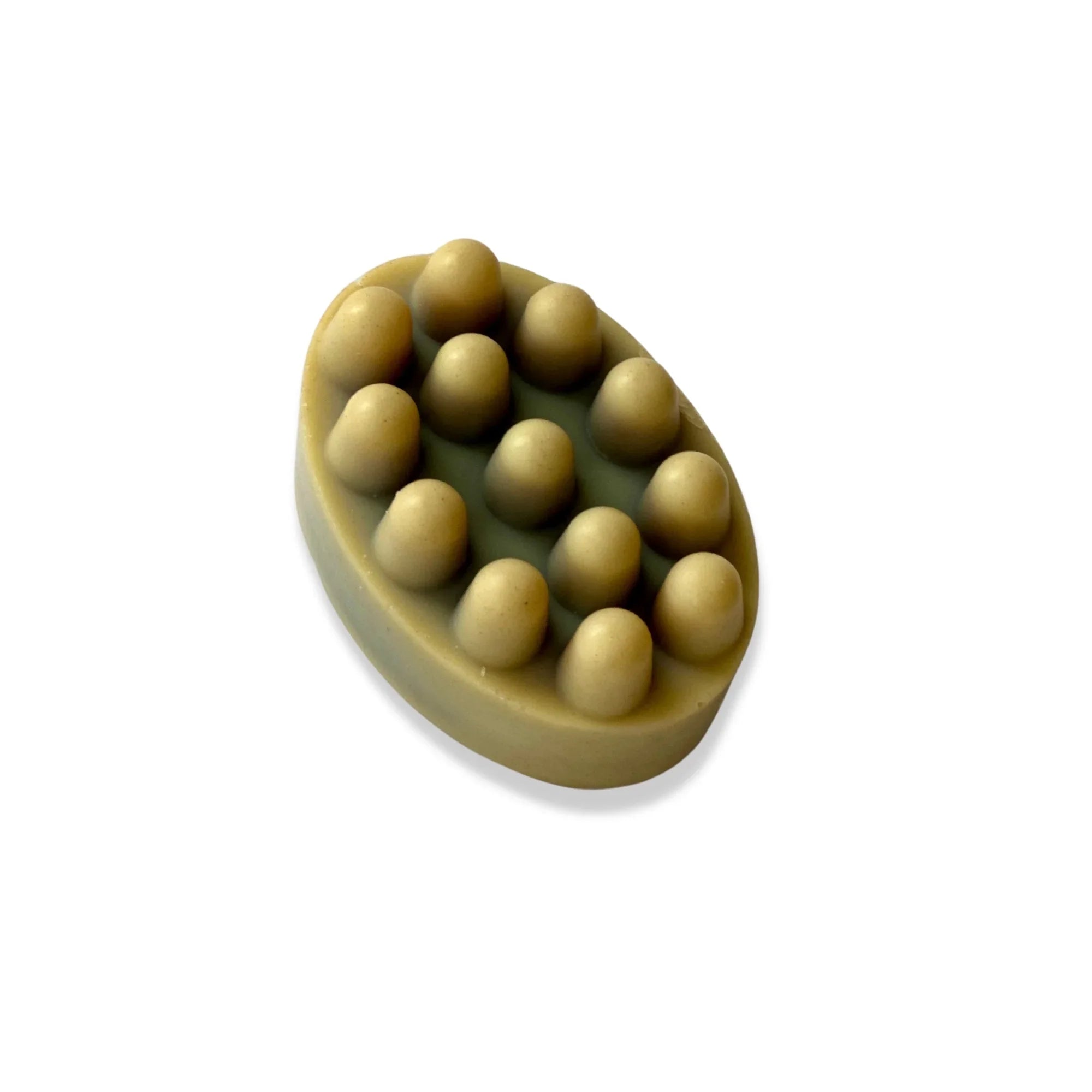 Oval-shaped beige massage soap bar with rounded nubs on top for exfoliation
