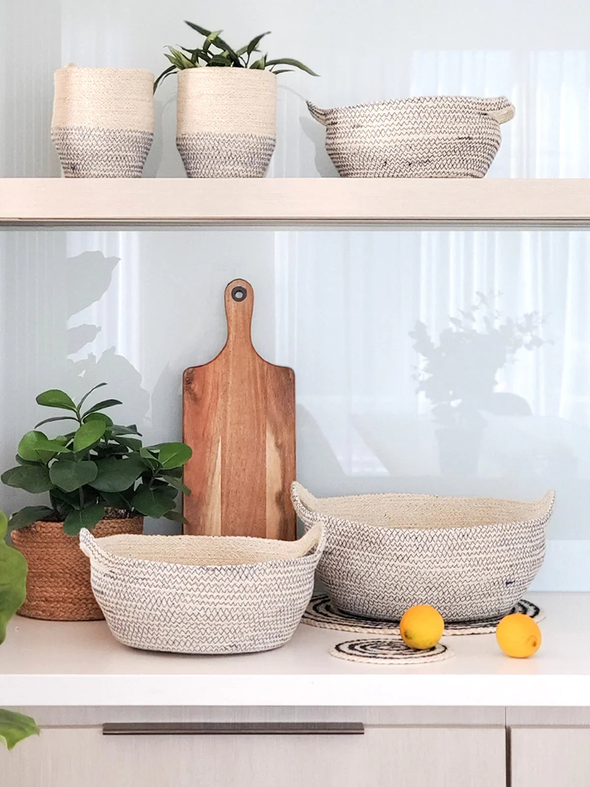 Modern kitchen with woven rope baskets, cutting board, potted plants, and citrus fruit, styled for Qu!rk Boutique.